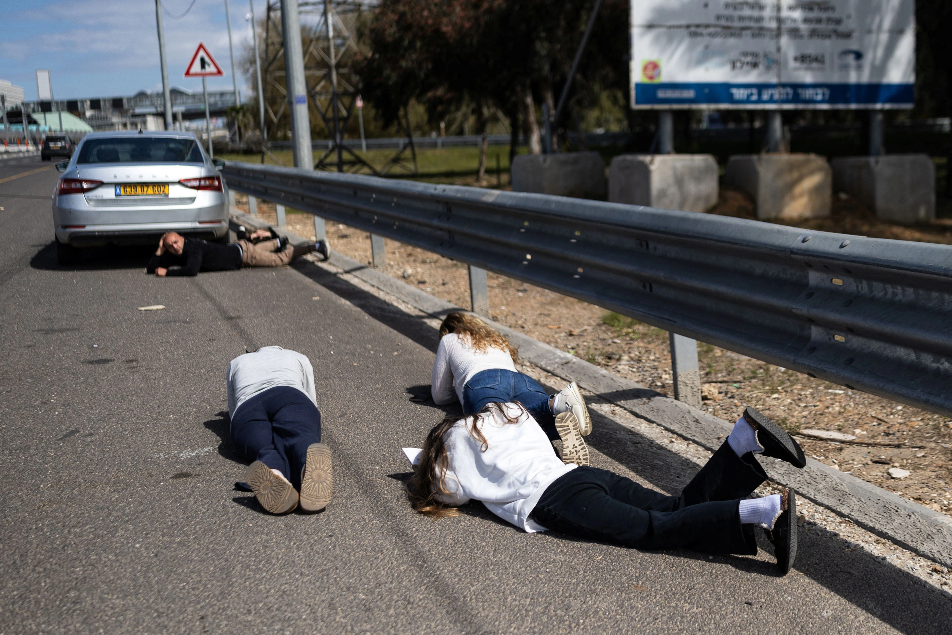 Israelis suchen während eines Raketenangriffs aus dem Iran Schutz, indem sie sich flach auf die Straße legen