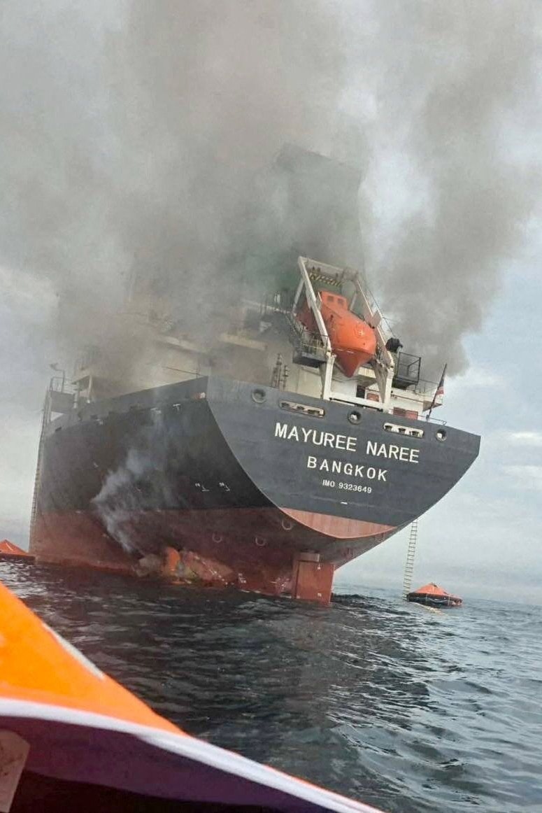 Das unter thailändischer Flagge fahrende Frachtschiff Mayuree Naree, umhüllt von schwarzem Rauch in der Straße von Hormus