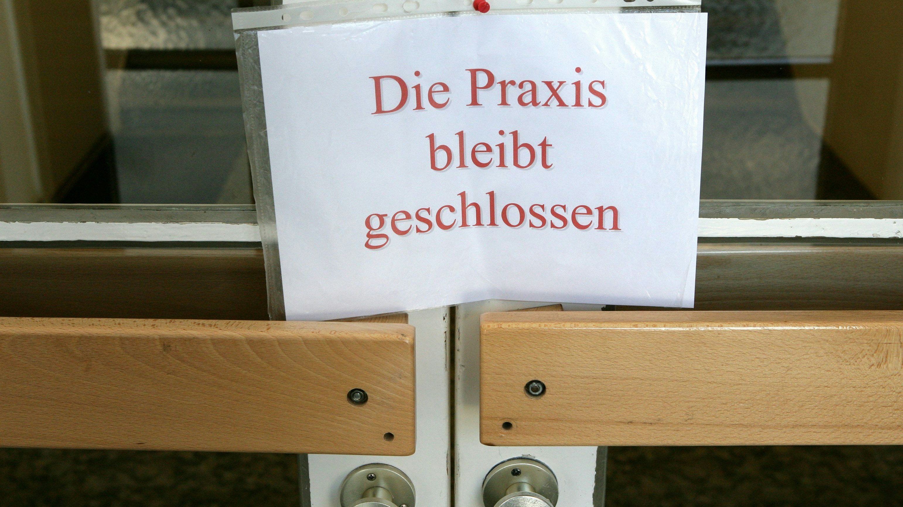 An einer Tür zu einer Arztpraxis im brandenburgischen Briesen (Oder-Spree) hängt am Mittwoch (24.05.2006) ein Schild mit der Aufschrift "Die Praxis bleibt geschlossen" (Symbolbild zum Thema Immer mehr Ärzte auf dem Land fehlen). Die Arbeit niedergelassener Ärzte soll künftig flexibler gestaltet werden. Das Bundeskabinett berät dazu am Mittwoch über Änderungen am Vertragsarztrecht. Damit soll unter anderem dem Ärztemangel in ländlichen Gebieten begegnet werden. Foto: Patrick Pleul +++(c) dpa - Report+++
