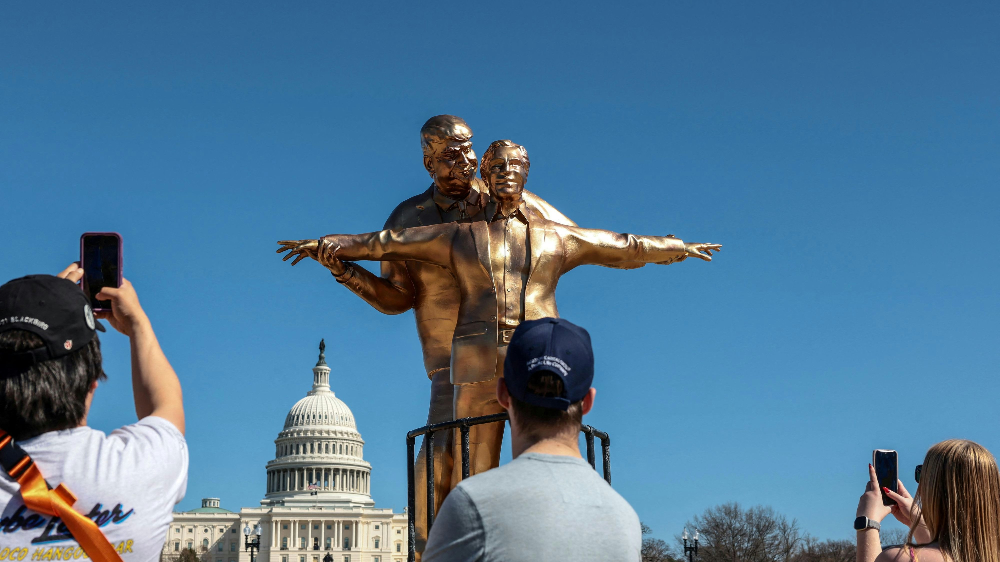 People look at a statue depicting U.S. President Donald Trump and convicted sex offender Jeffrey Epstein, entitled “The King of the World”, on the National Mall in Washington, D.C., U.S., March 10, 2026. REUTERS/Evelyn Hockstein