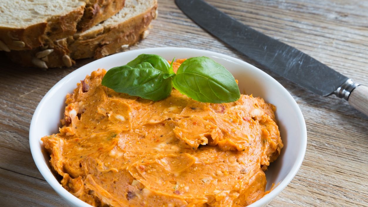 Herb butter tomato in a bowl on wood.