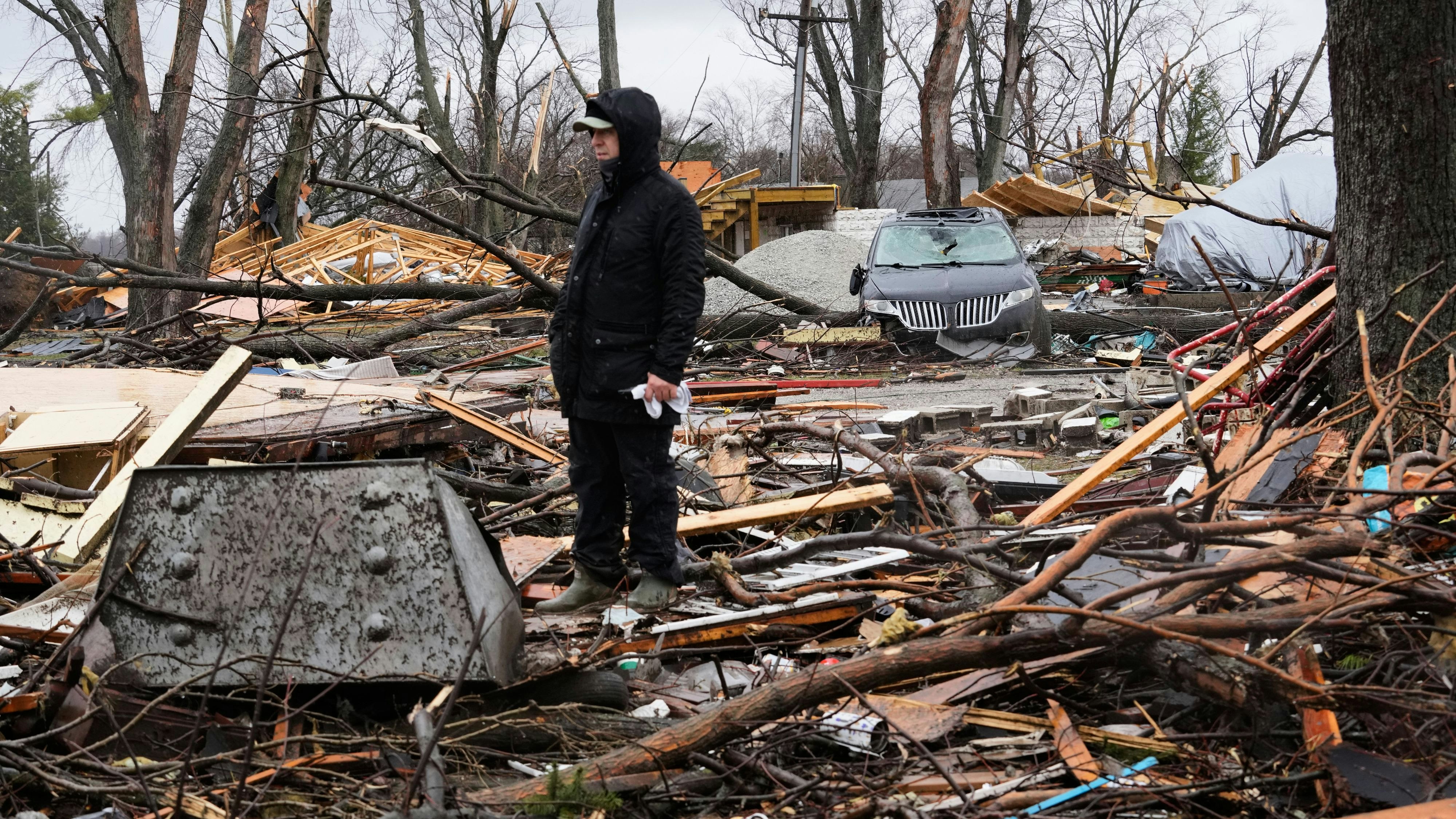 Josh Johnson searches through his belongings amid debris in the aftermath of a powerful storm that ripped through the area a day earlier, in Aroma Park, Ill., Wednesday, March 11, 2026. (AP Photo/Nam Y. Huh)