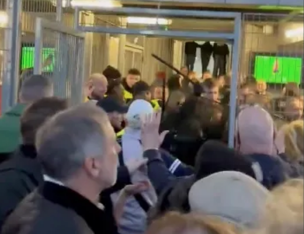 Ein Polizist schlägt mit einem Schlagstock auf Villa-Fans ein. 