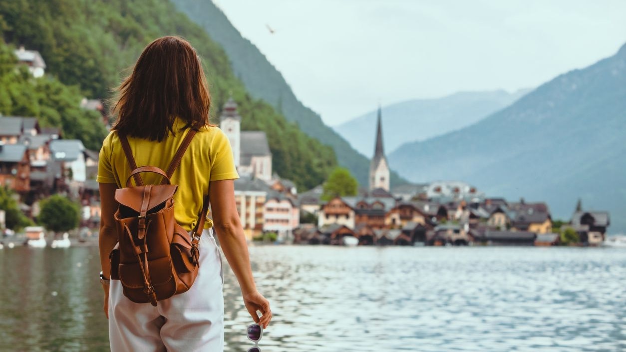 woman standing on the beach looking at hallstatt city copy space