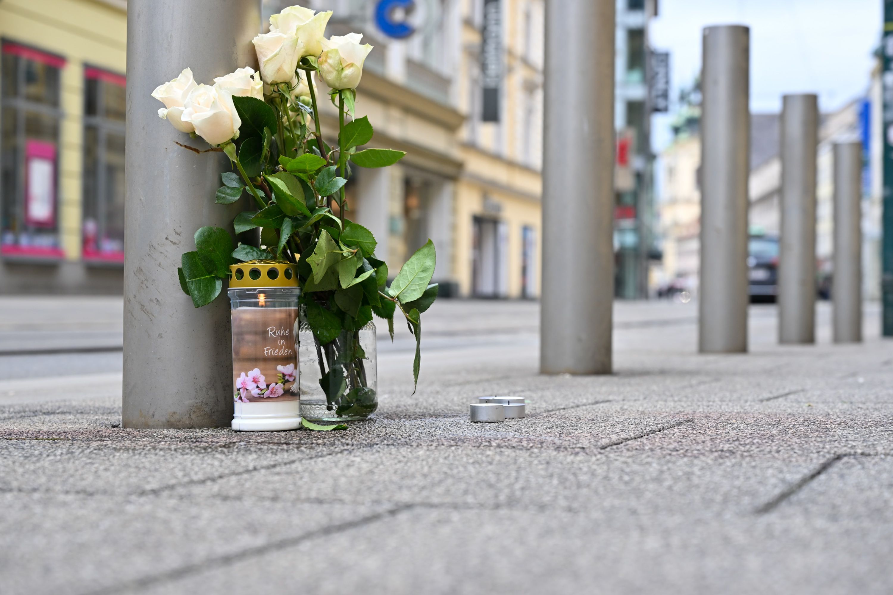 Kerzen und weiße Rosen stehen am Tag nach der tödlichen Messerattacke in der Linzer Innenstadt. Bei dem Angriff am Samstag wurde ein Mann tödlich verletzt, ein weiterer Mann schwer verletzt.