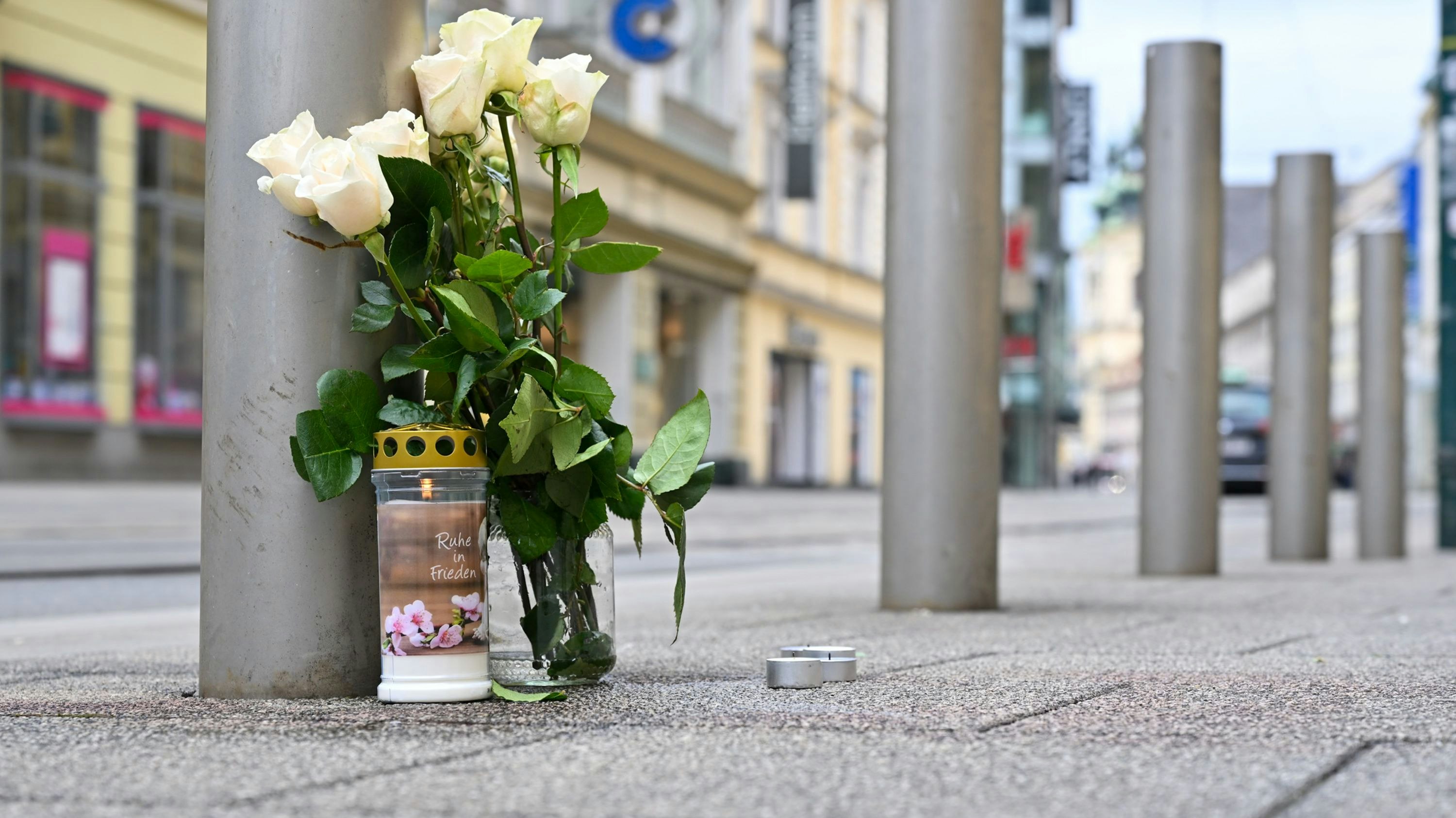 Kerzen und weiße Rosen stehen am Tag nach der tödlichen Messerattacke in der Linzer Innenstadt. Bei dem Angriff am Samstag wurde ein Mann tödlich verletzt, ein weiterer Mann schwer verletzt.