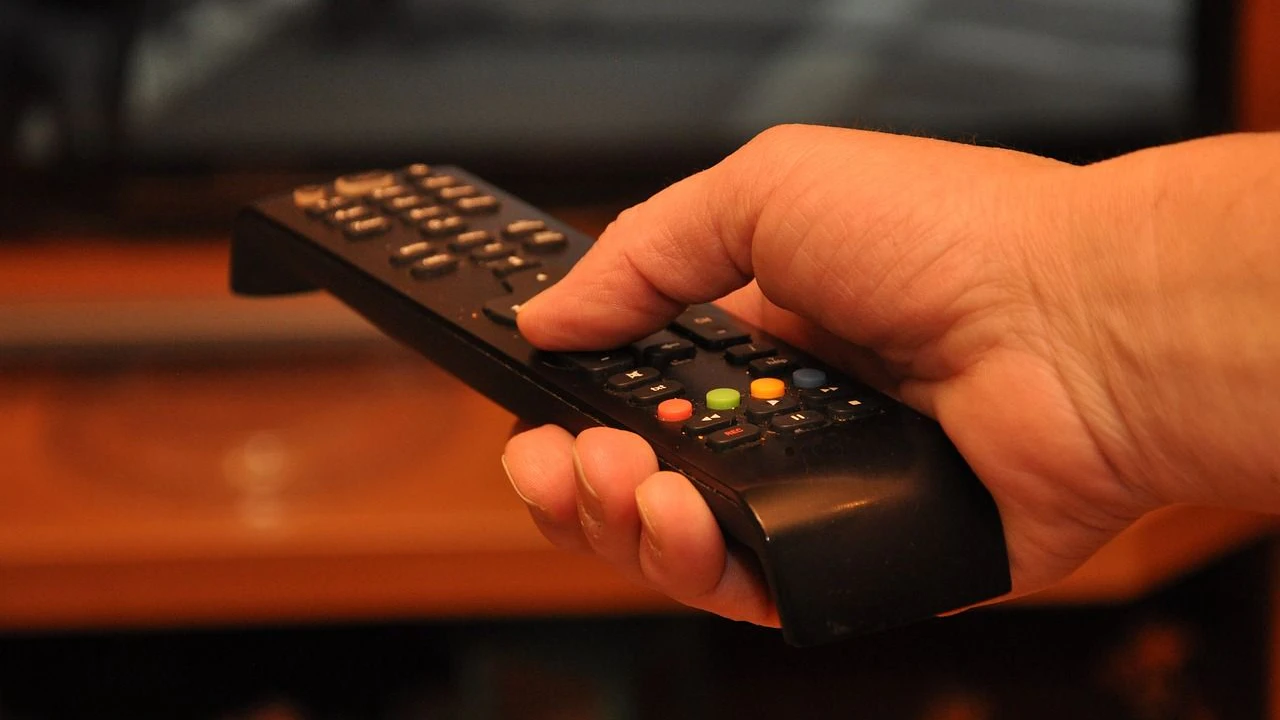 Mit Fernbedienung vor dem Fernseher