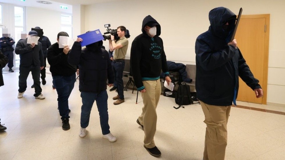 Streng bewachte Angeklagte am Weg zum Prozess. 