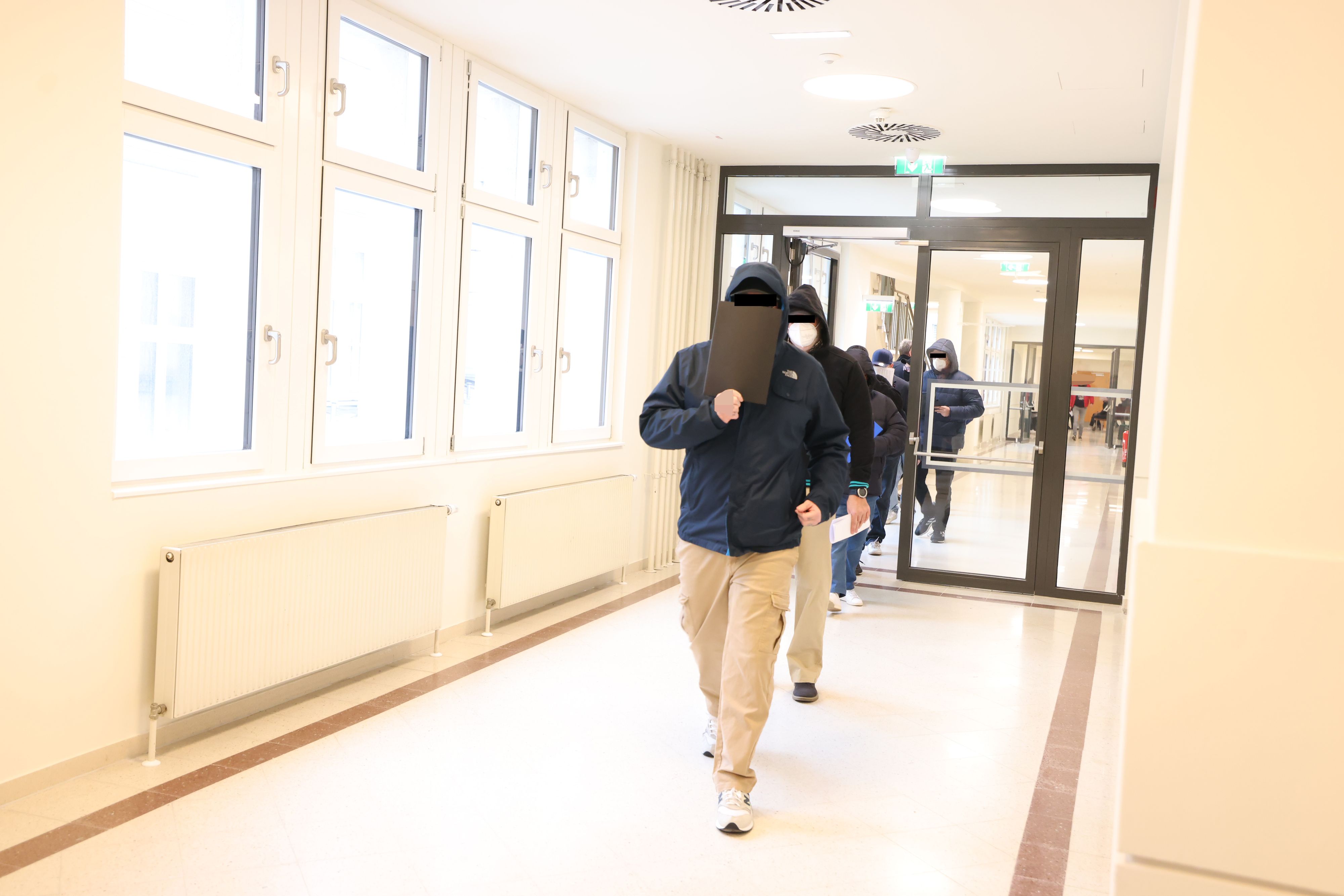 Die Angeklagten auf dem Weg in den Gerichtssaal.