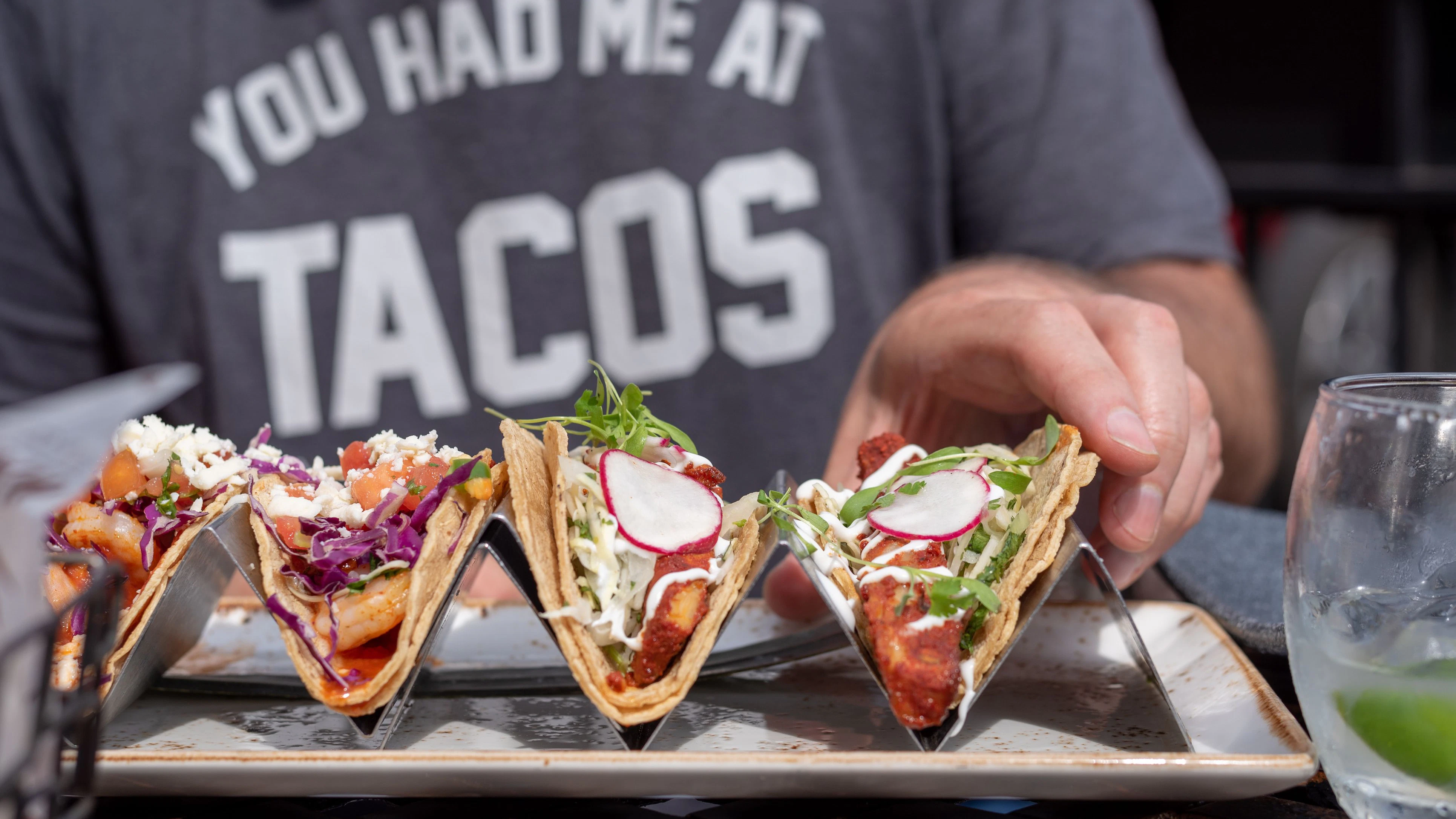 closeup of man reaching for taco outside in summer