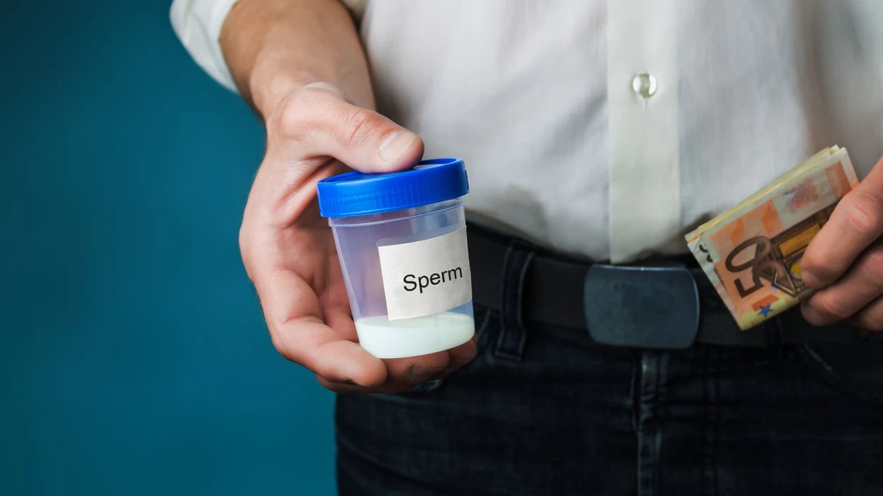 Money and container with sperm in hands of man. Concept of donating sperm