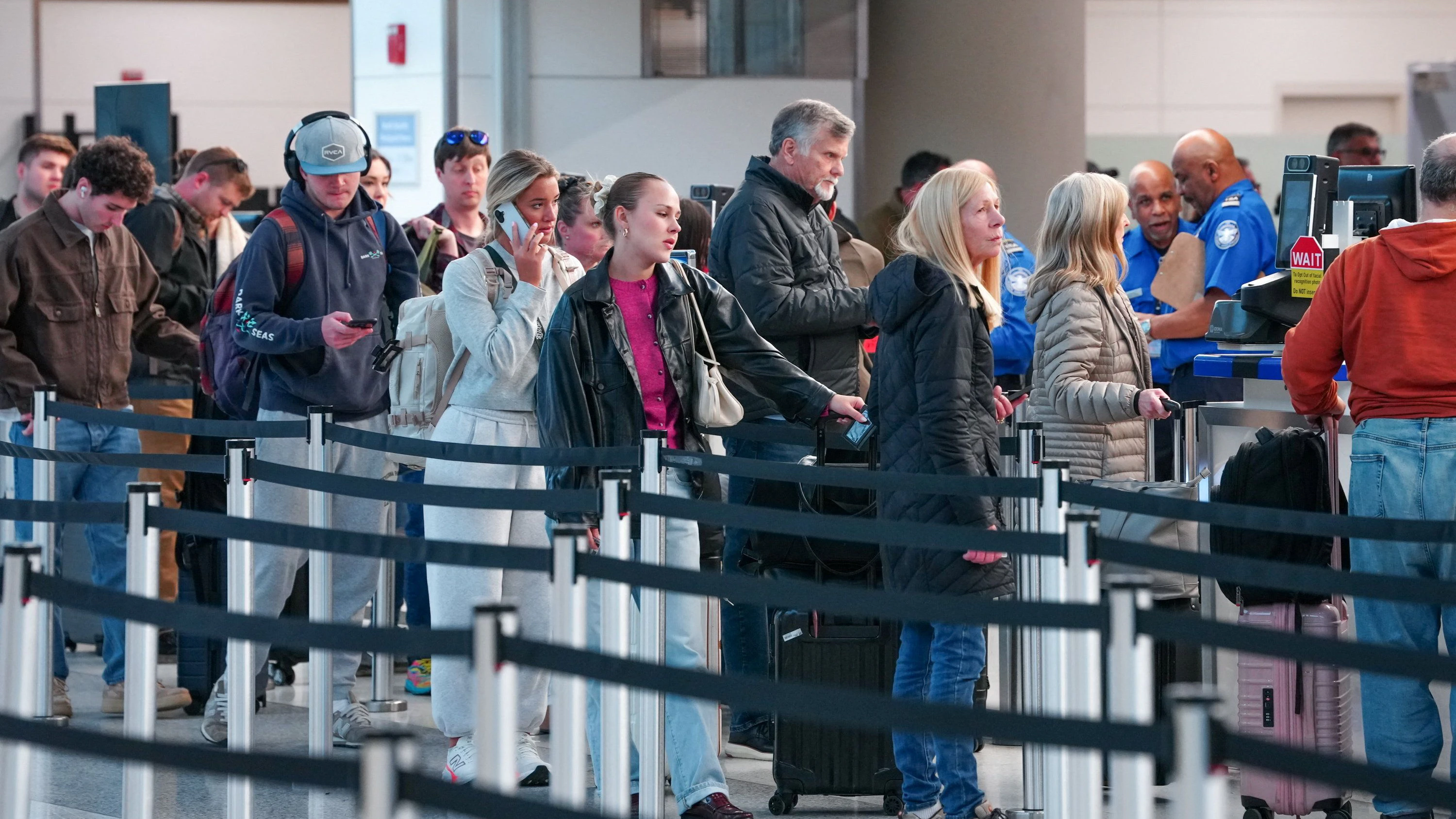 Passengers walk through a queue to enter a TSA security checkpoint at Ronald Reagan International Airport in Arlington, Virginia., U.S., March 15, 2026. REUTERS/Aaron Schwartz