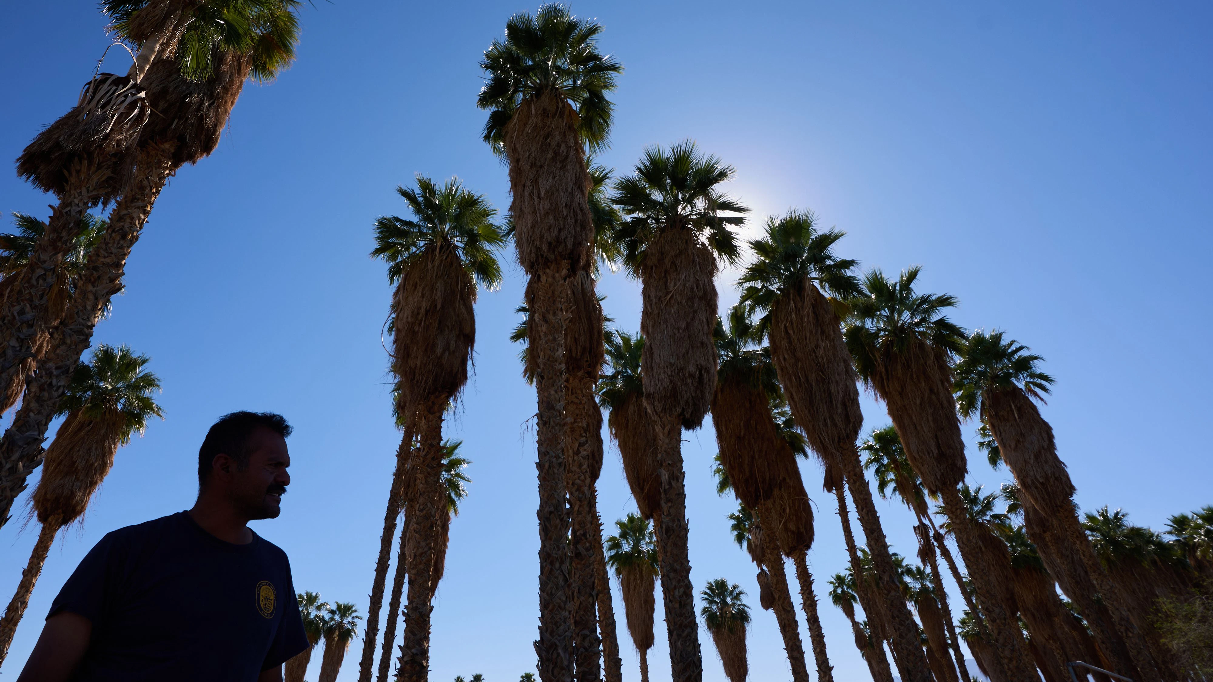 Rubin Pantaleon stays in the shade while waiting for work washing car windshields as a record-breaking winter heat wave continues across the Southwest, Thursday, March 19, 2026, in Thermal, Calif. (AP Photo/Gregory Bull)