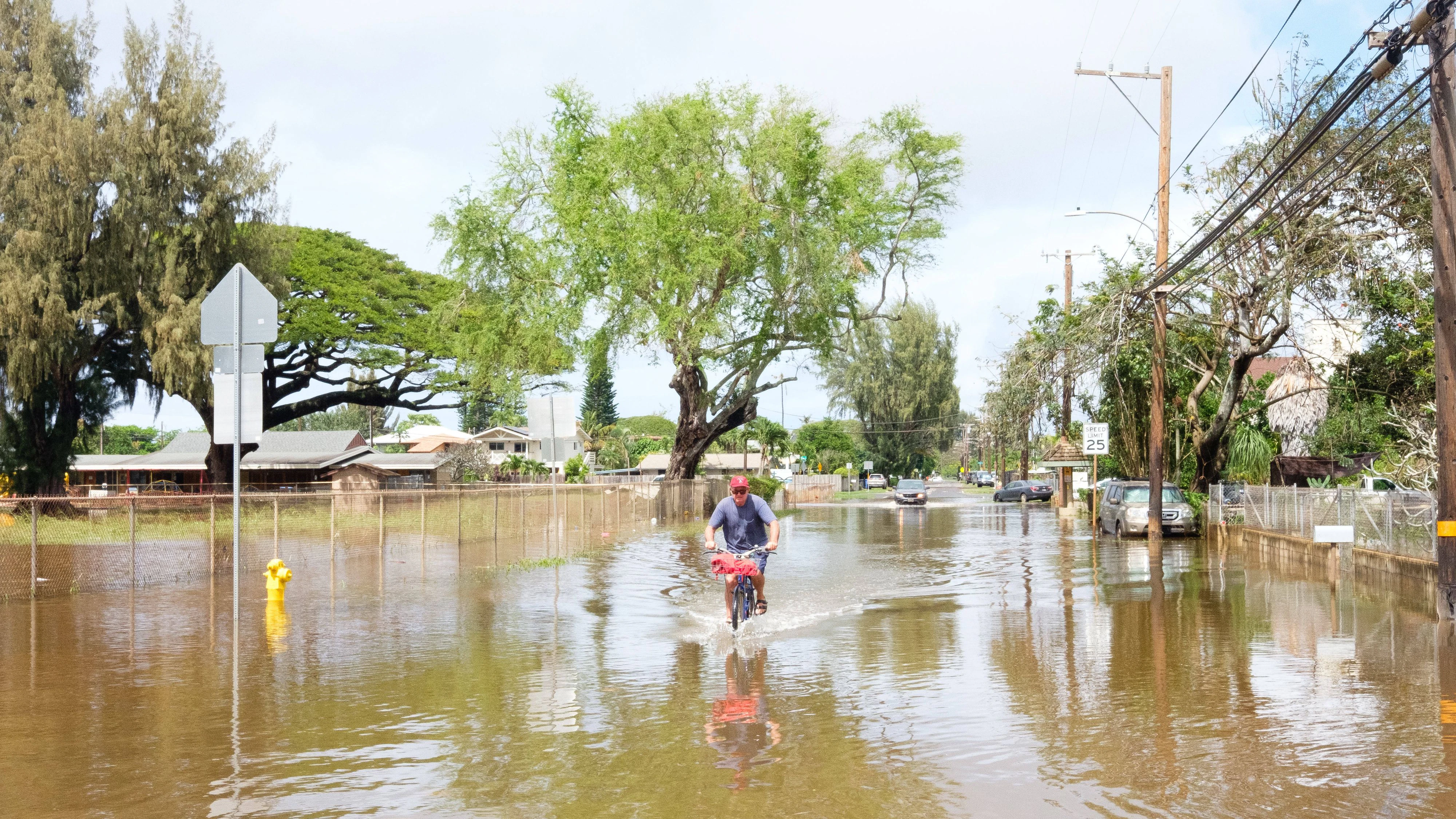 March 20, 2026, Waialua, Hawaii, USA: A Kona low southerly storm is currently flooding Oahu, Hawaii beginning in the wee hours of Saturday morning, March 20 with flooding danger forecast to last through March 21, the towns of Waialua and Haleiwa most impacted. Damage there includes homes washed from foundations, and widespread inundation of farms in Waialua, a principal farming district on the island of Oahu. Hundreds face evacuation as flooding increases with the Wahiawa dam at Lake Wilson at risk of failure according to authorities, potentially endangering hundreds downstream. More rain is falling and forecast overnight. A resident rides through floodwaters. Waialua USA - ZUMAm255 20260320_znp_m255_010 Copyright: xJ.xMattx