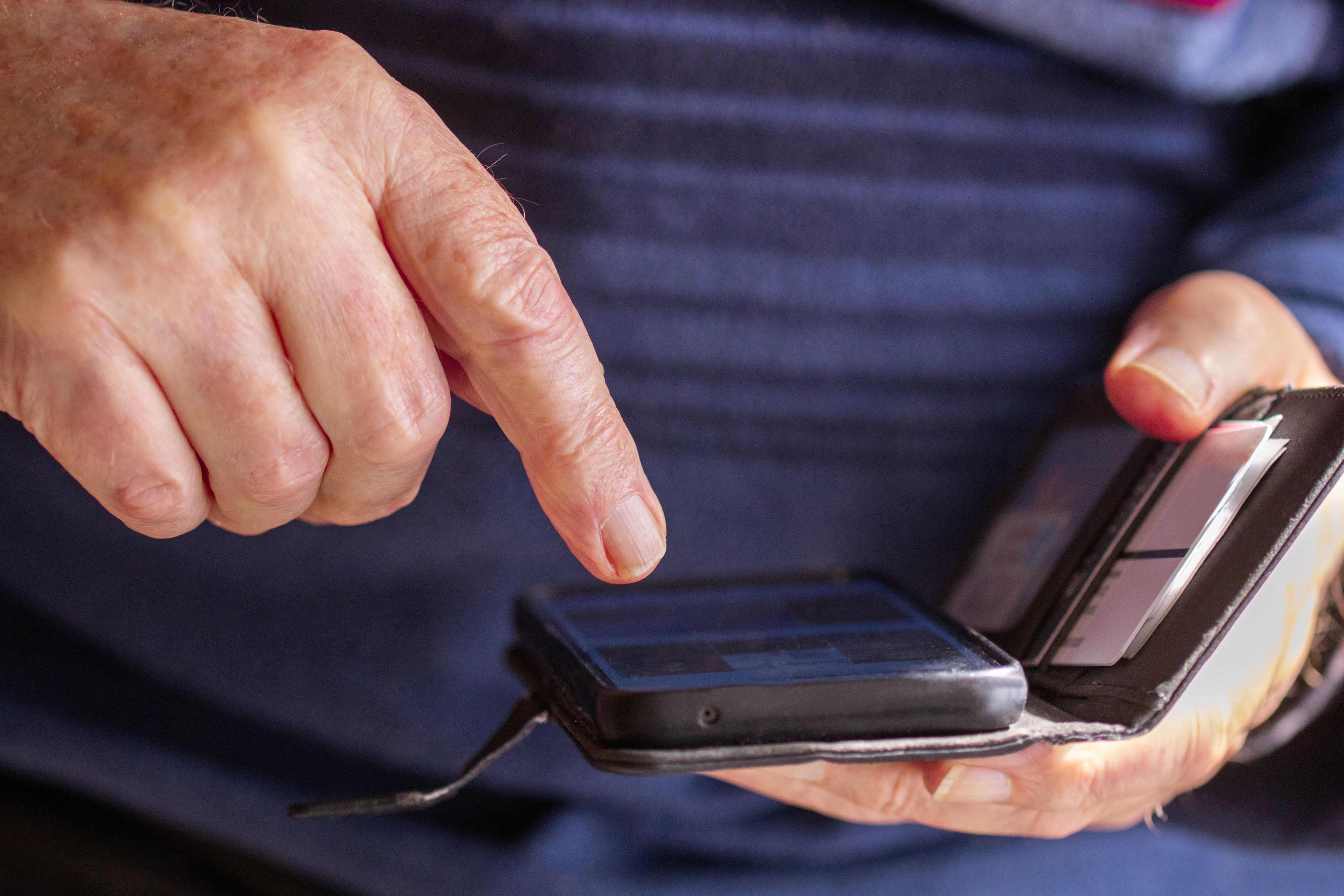 Ein Pensionist zeigt auf sein Handy – eine unerwartete Rechnung bringt ihn um den Schlaf. (Symbolfoto)