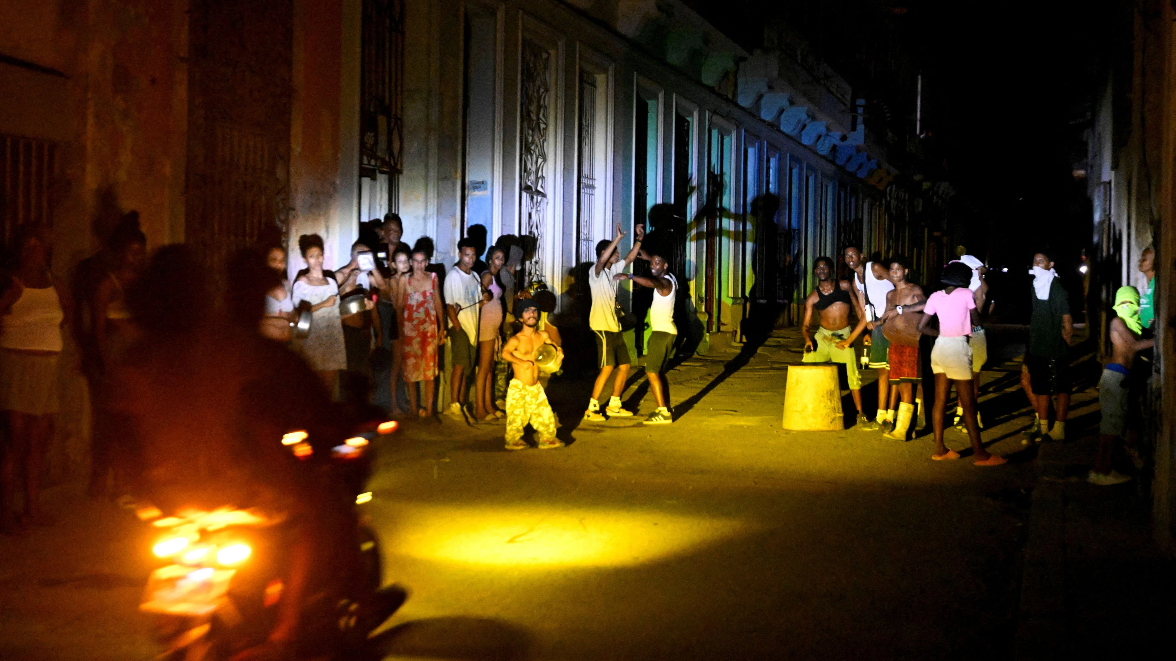 FILE PHOTO: People gather on a street during a blackout as Cuba's national electric grid collapsed, according to the country's grid operator, leaving around 10 million people without power amid a U.S.-imposed oil blockade, in Havana, Cuba March 16, 2026. REUTERS/Norlys Perez/File Photo