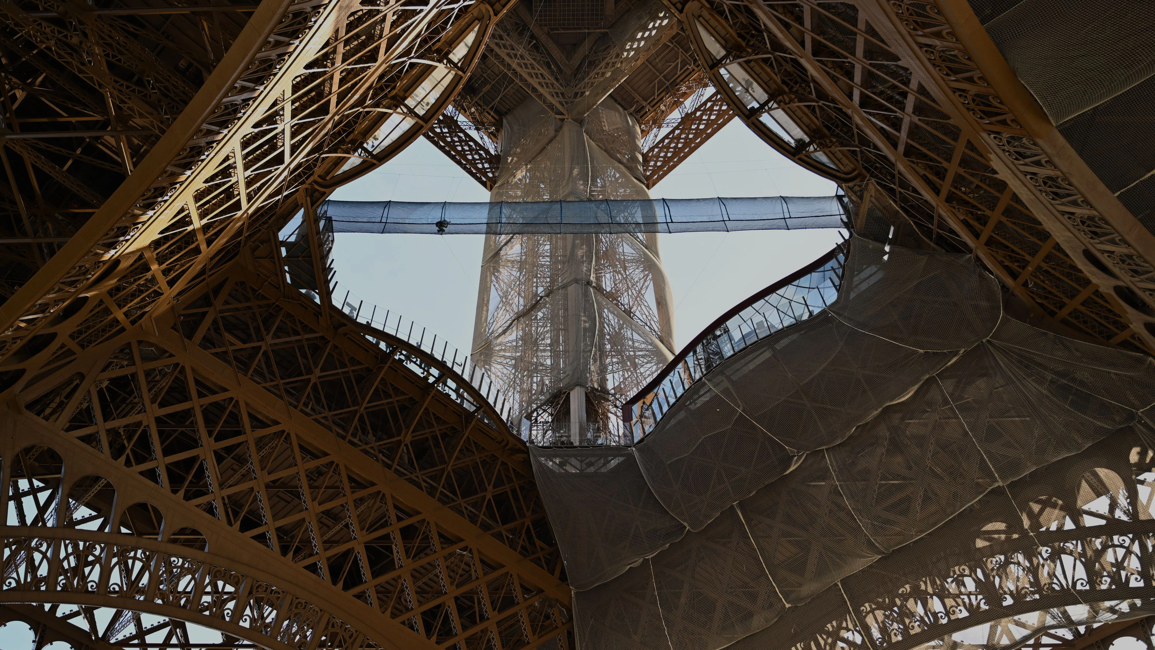 A visitor crosses the Vertigo of the Tower, an attraction made of a 40-meter-long bridge at a height of 60 meters designed with nets and set up on the 1st floor of the Eiffel Tower, in Paris, Tuesday, March 17, 2026. (AP Photo/Emma Da Silva)