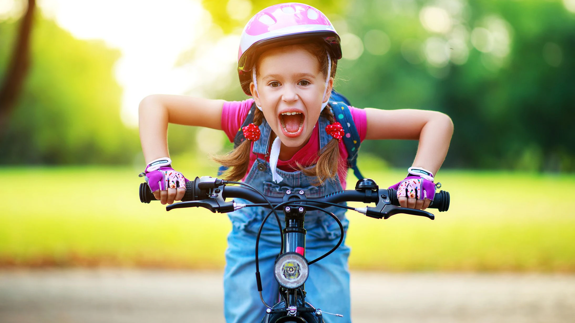 happy cheerful child girl riding a bike in Park in the nature