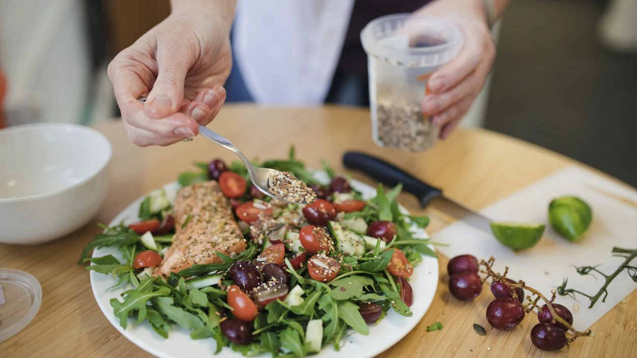 A mid adult woman prepares her lunch in the office.