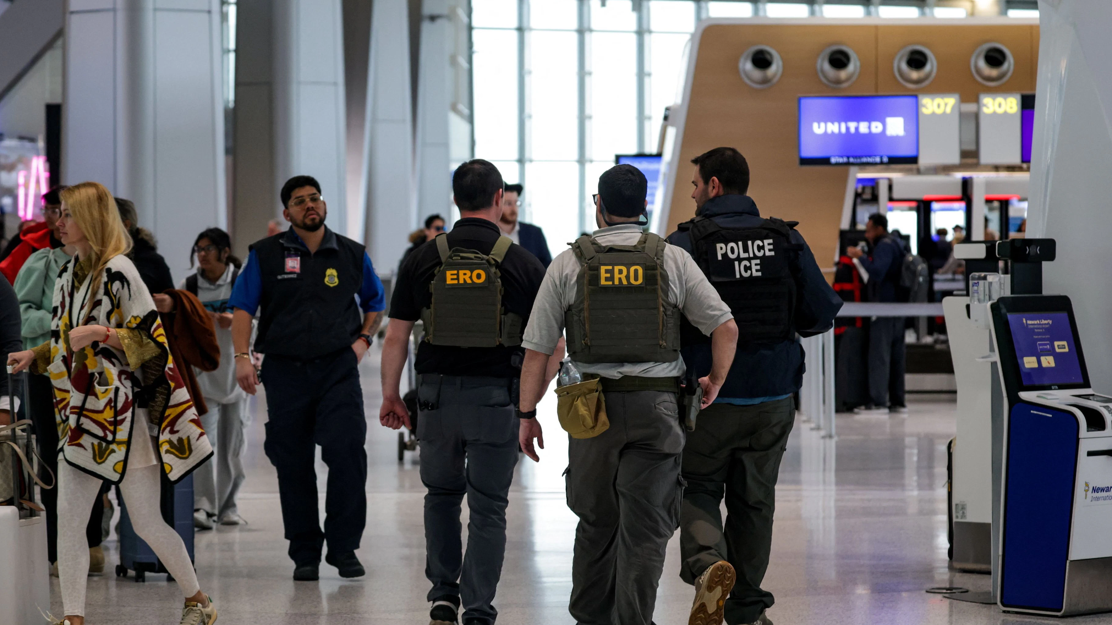 Immigration and Customs Enforcement (ICE) agents walk at Newark Liberty International Airport, as hundreds of them were ordered to deploy to airports to help fill TSA staffing gaps, in Newark, New Jersey, U.S., March 23, 2026. REUTERS/Jeenah Moon