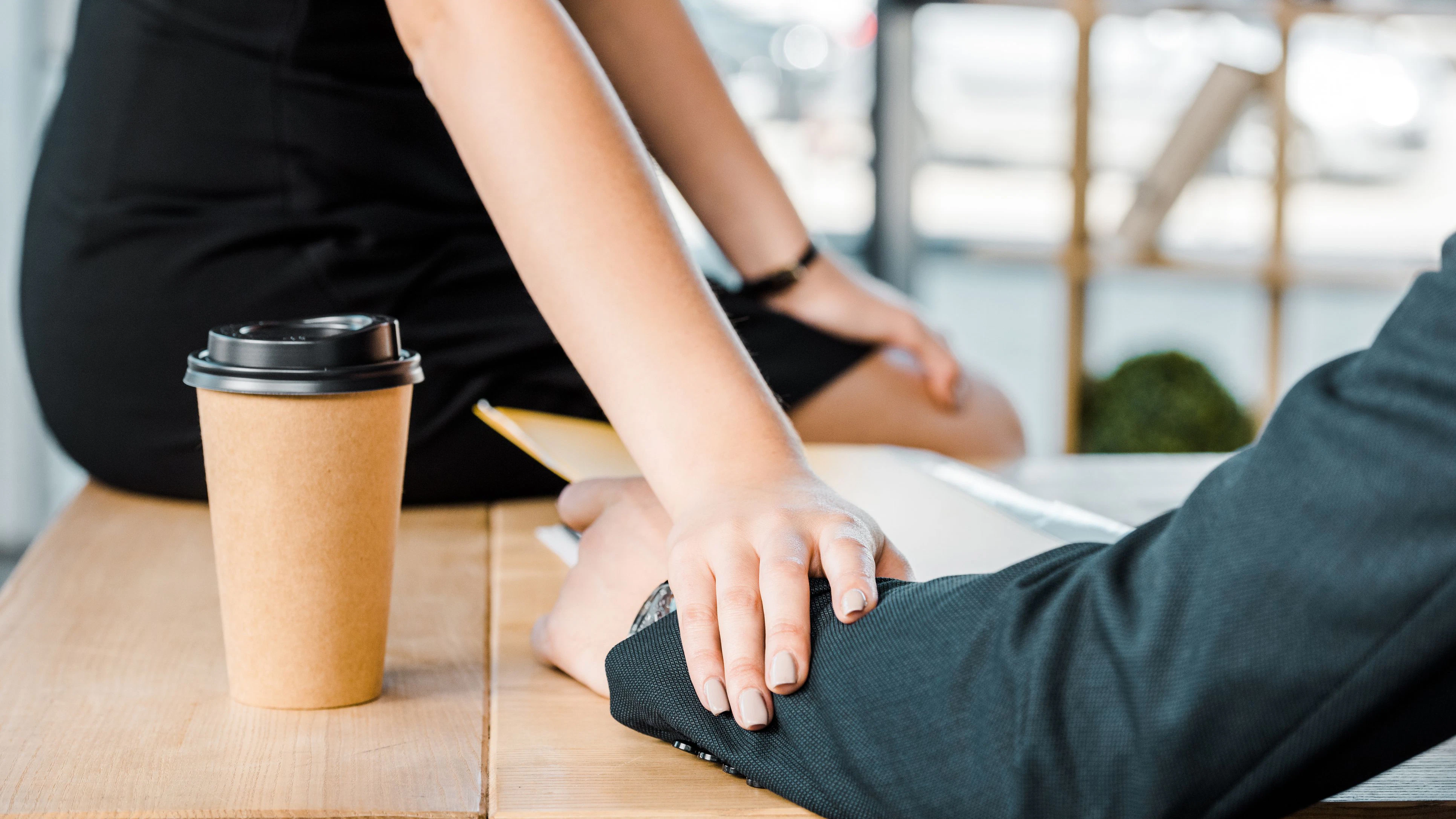 cropped shot of businesswoman flirting with colleague at workplace in office