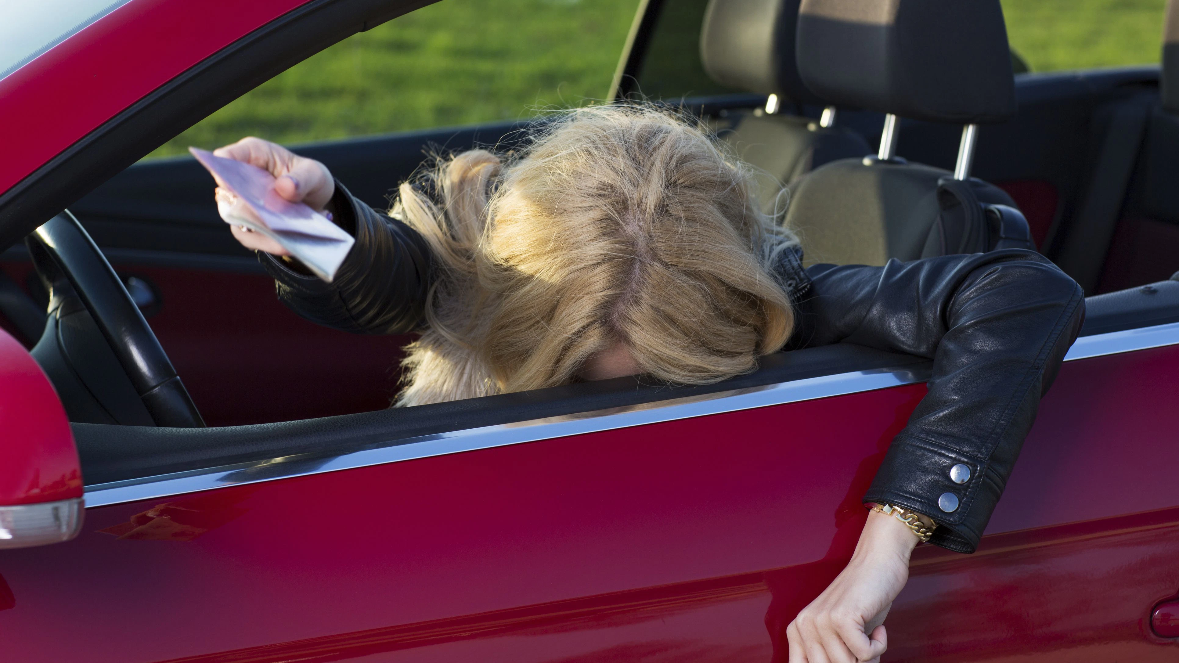 Totaly drunk young girl is giving licence and registration to police officer