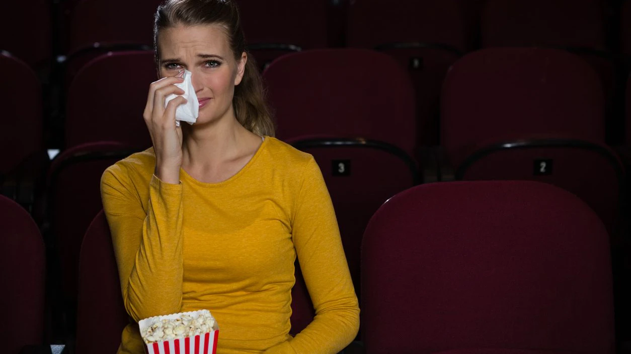 Woman crying while watching movie in theatre