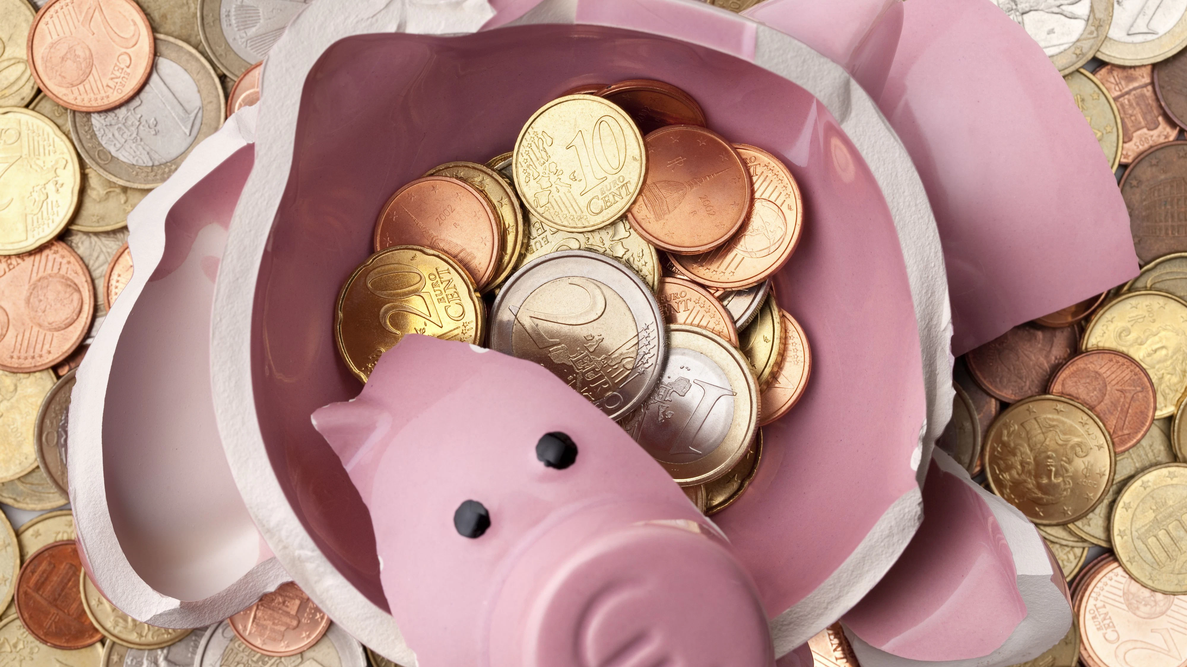 Savings. Broken piggy bank with euro coins.