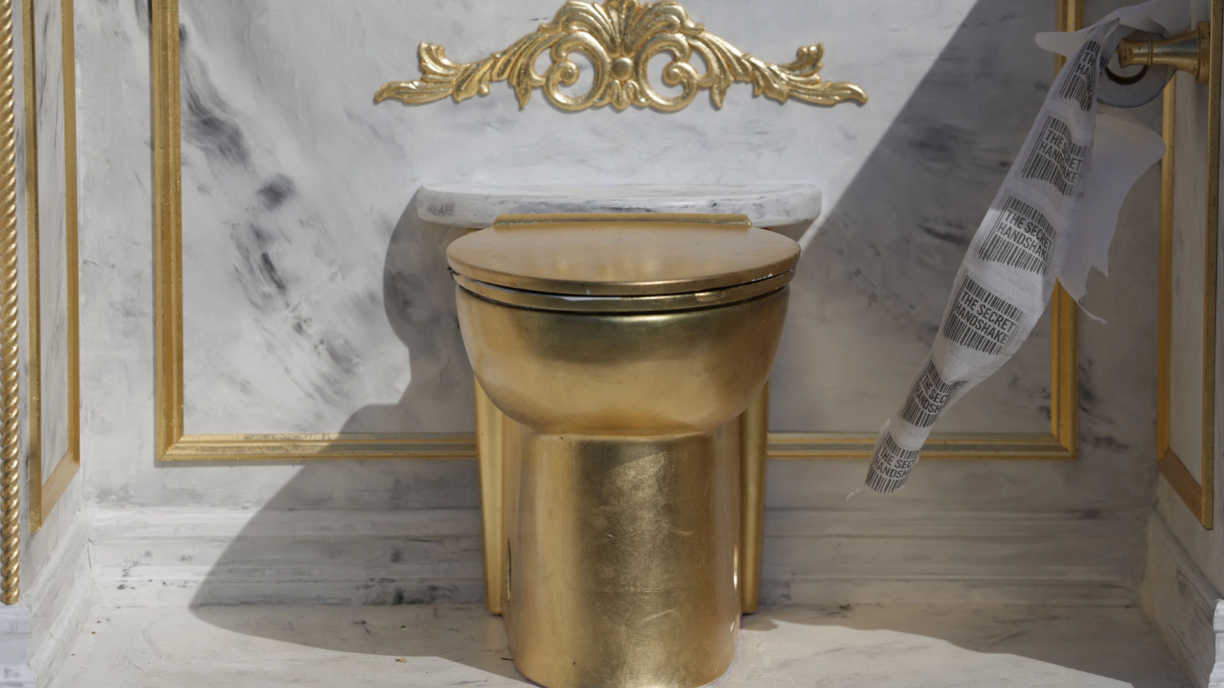 Toilet paper with the message "the secret handshake" written on it moves with the wind as it is displayed as part of a statue featuring a large golden toilet, titled "A Throne Fit for a King," near the Lincoln Memorial on the National Mall in Washington, D.C., U.S., March 30, 2026. REUTERS/Evelyn Hockstein