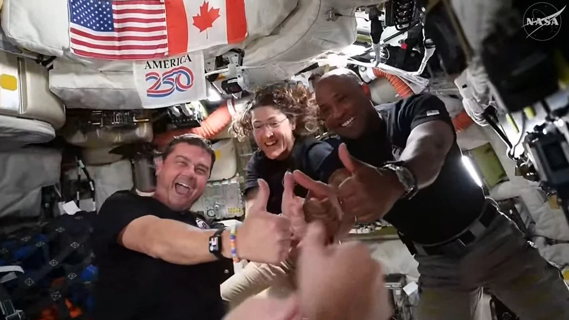 *** HANDOUT *** TOPSHOT - This screengrab from a NASA livestream shows Artemis II crew members Reid Wiseman, Christina Koch and Victor Glover giving a thumbs up aboard the Orion spacecraft on April 6, 2026. Artemis astronauts at the outer edge of human space travel had an emotional moment April 6 as they named a crater in honor of the deceased wife of mission commander Reid Wiseman. "It's a bright spot on the Moon. And we would like to call it Carroll," Canadian astronaut Jeremy Hansen told a live broadcast. The crater can be seen "at certain times of the Moon's transit around Earth," he said. (Photo by Handout / NASA / AFP) / RESTRICTED TO EDITORIAL USE - MANDATORY CREDIT "AFP PHOTO / NASA" - HANDOUT - NO MARKETING NO ADVERTISING CAMPAIGNS - DISTRIBUTED AS A SERVICE TO CLIENTS