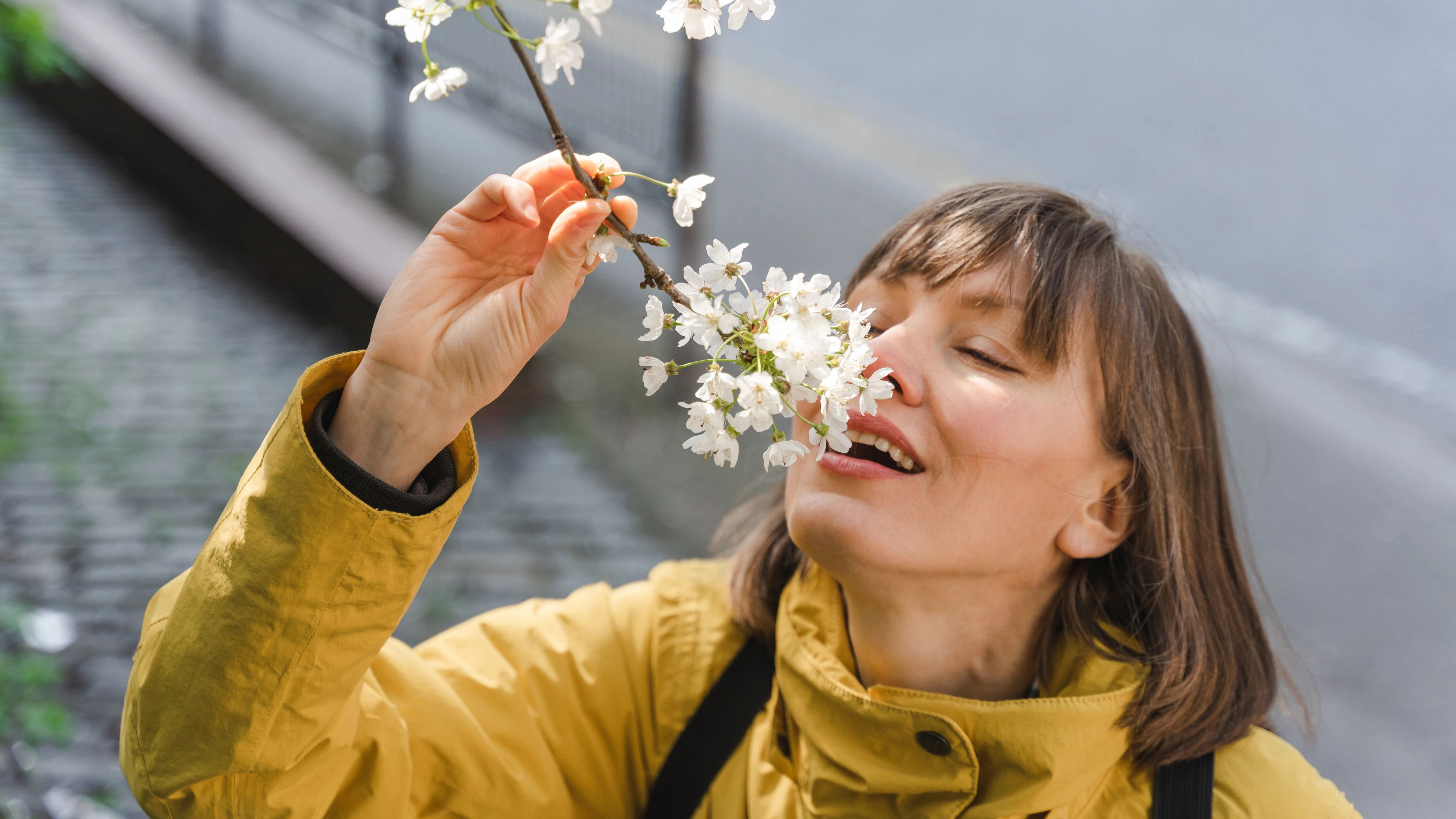 Frau riecht an Blumen...