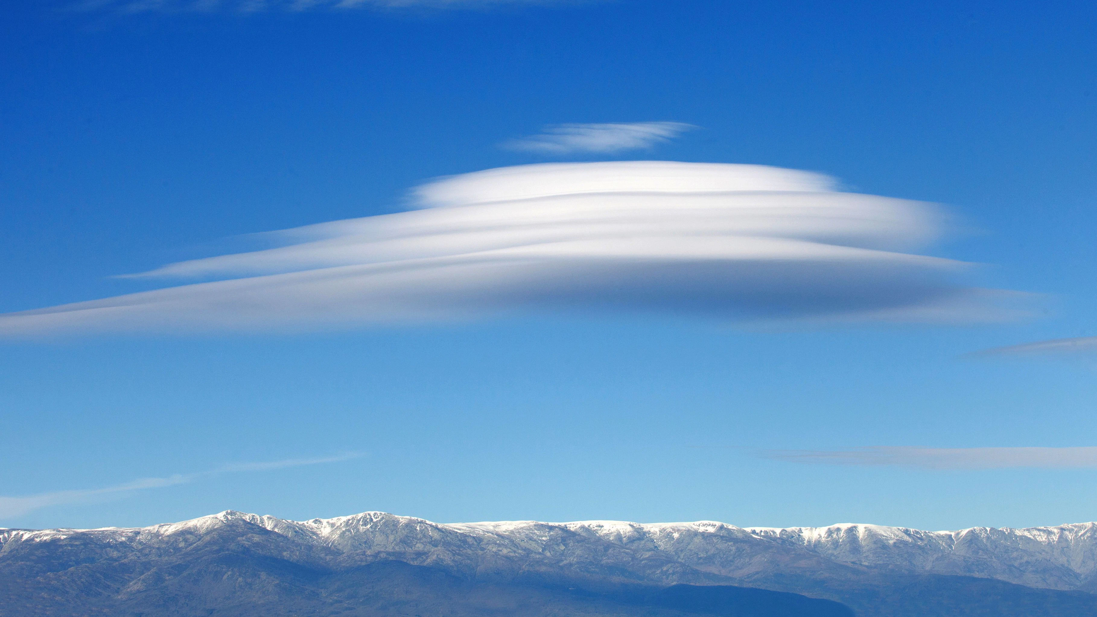 Big lenticularis cloud with a snowed mountain of background