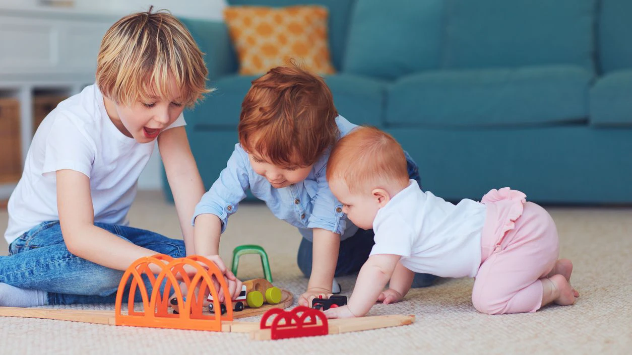 cute kids, siblings playing toys together on the carpet at home