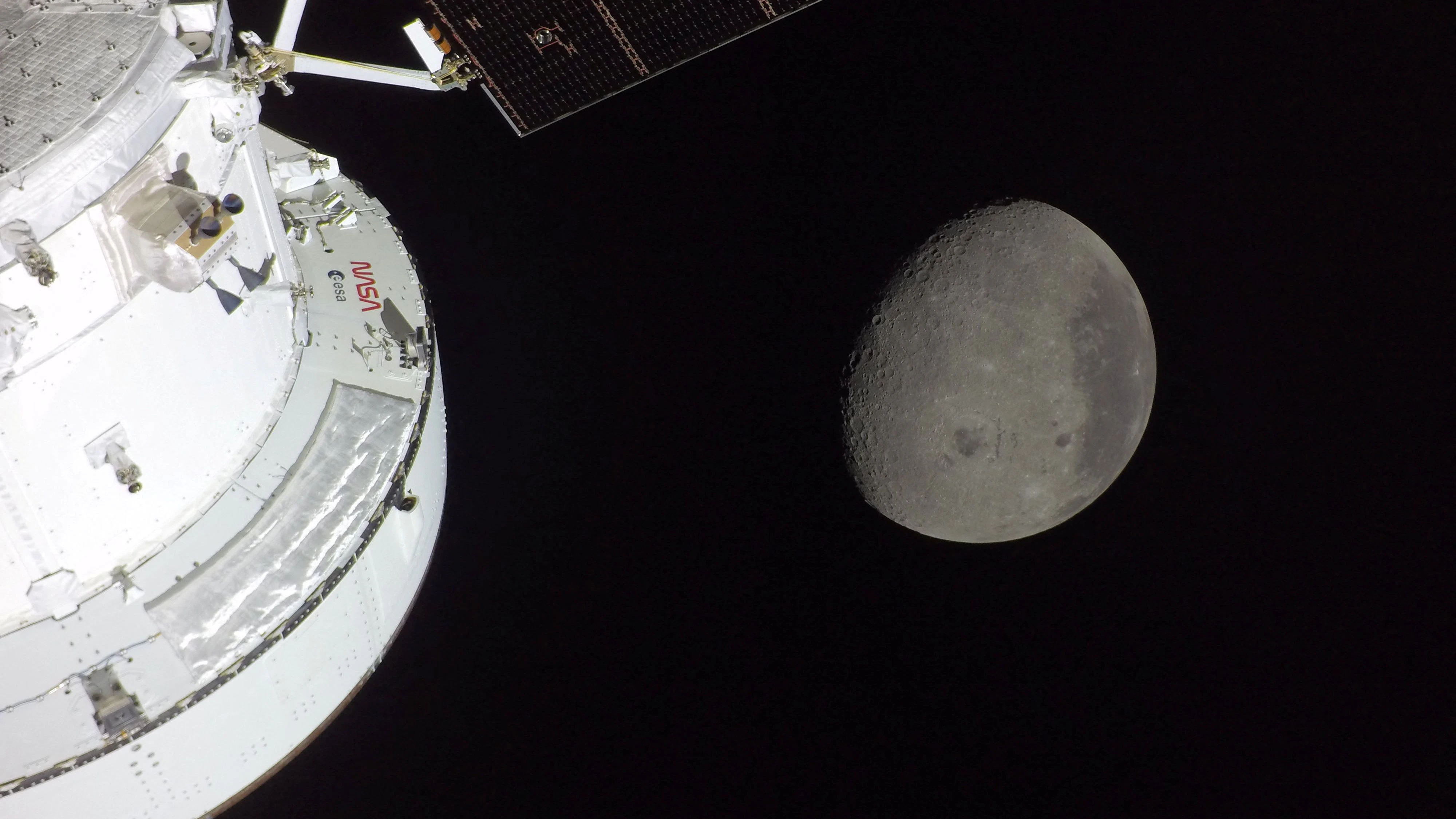 A view of NASA's Orion spacecraft in the foreground, lit up by the Sun, as a waxing gibbous Moon is visible behind it, as photographed by one of the cameras on the Orion spacecraft's solar arrays during the Artemis II crew's flyby of the Moon April 6, 2026. According to the image file data the picture was taken with a GoPro HERO4 Black camera.   NASA/Handout via REUTERS THIS IMAGE HAS BEEN SUPPLIED BY A THIRD PARTY   