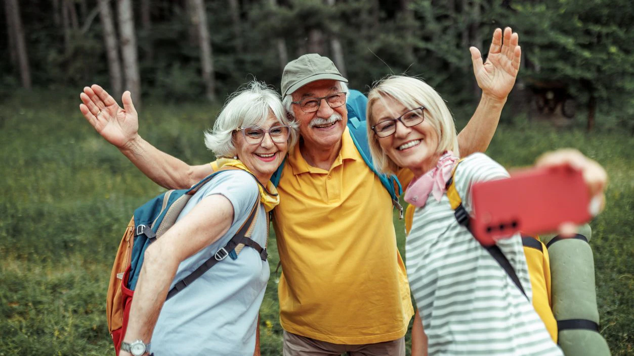 Senior hikers taking selfie while hiking together at forest