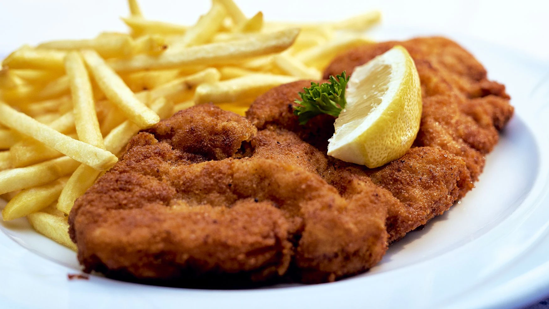 original schnitzel with fries and salad in the restaurant
