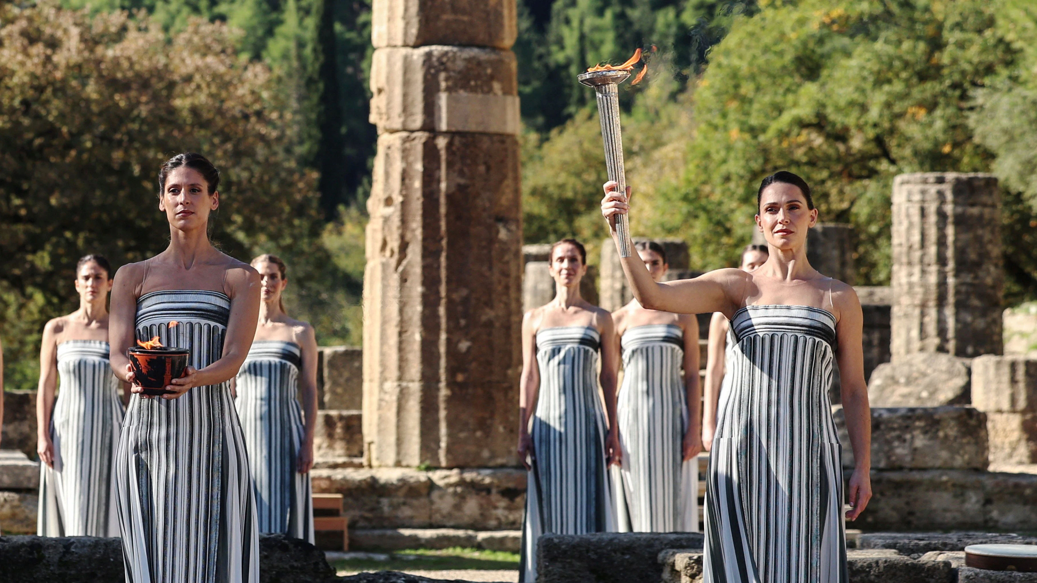 Olympics - 2026 Milano-Cortina Winter Olympics - Dress rehearsal of the Olympics Flame Lighting Ceremony - Ancient Olympia, Greece - November 24, 2025 Greek actress Mary Mina, playing the role of High Priestess, carries the Olympic flame during the dress rehearsal ahead of the ceremony  REUTERS/Louisa Gouliamaki 