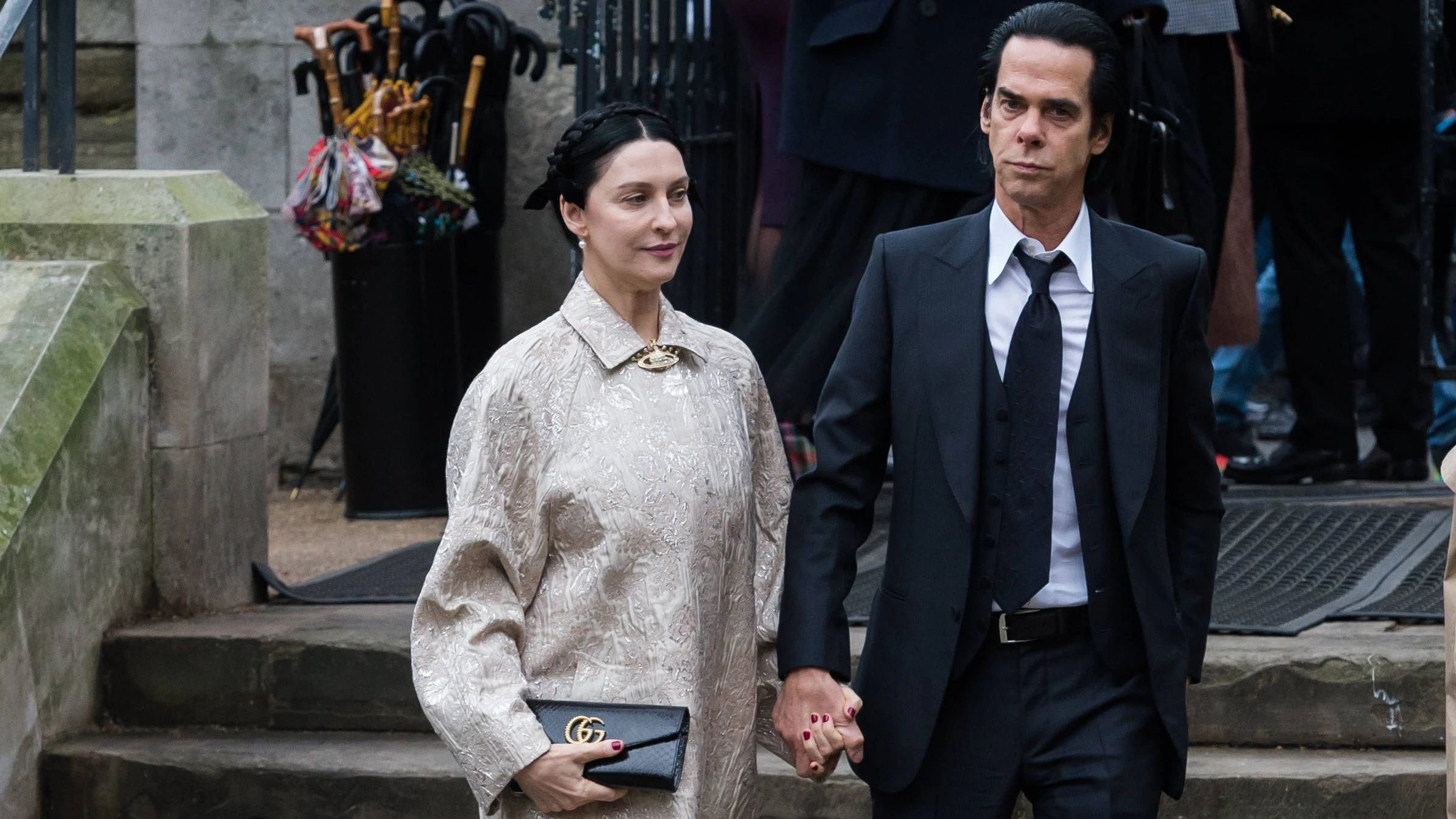 Auch nach fast 27 Jahren Ehe stets Hand in Hand: Susie und Nick Cave beim Begräbnis von Vivienne Westwood vor der Southwark Cathedral in <a data-li-document-ref="120172967" href="https://www.heute.at/s/brandanschlag-auf-juedischen-rettungsdienst-in-london-120172967">London</a>.