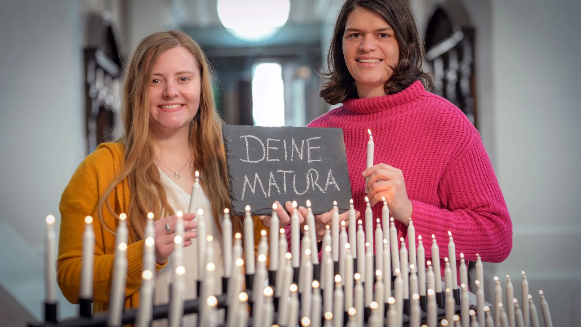 Antonela Petricevic (Junge Kirche) und Manuela Maier (Katholische Jugend) aus der Erzdiözese Salzburg mit Maturakerzen in der Kollegienkirche in Salzburg.