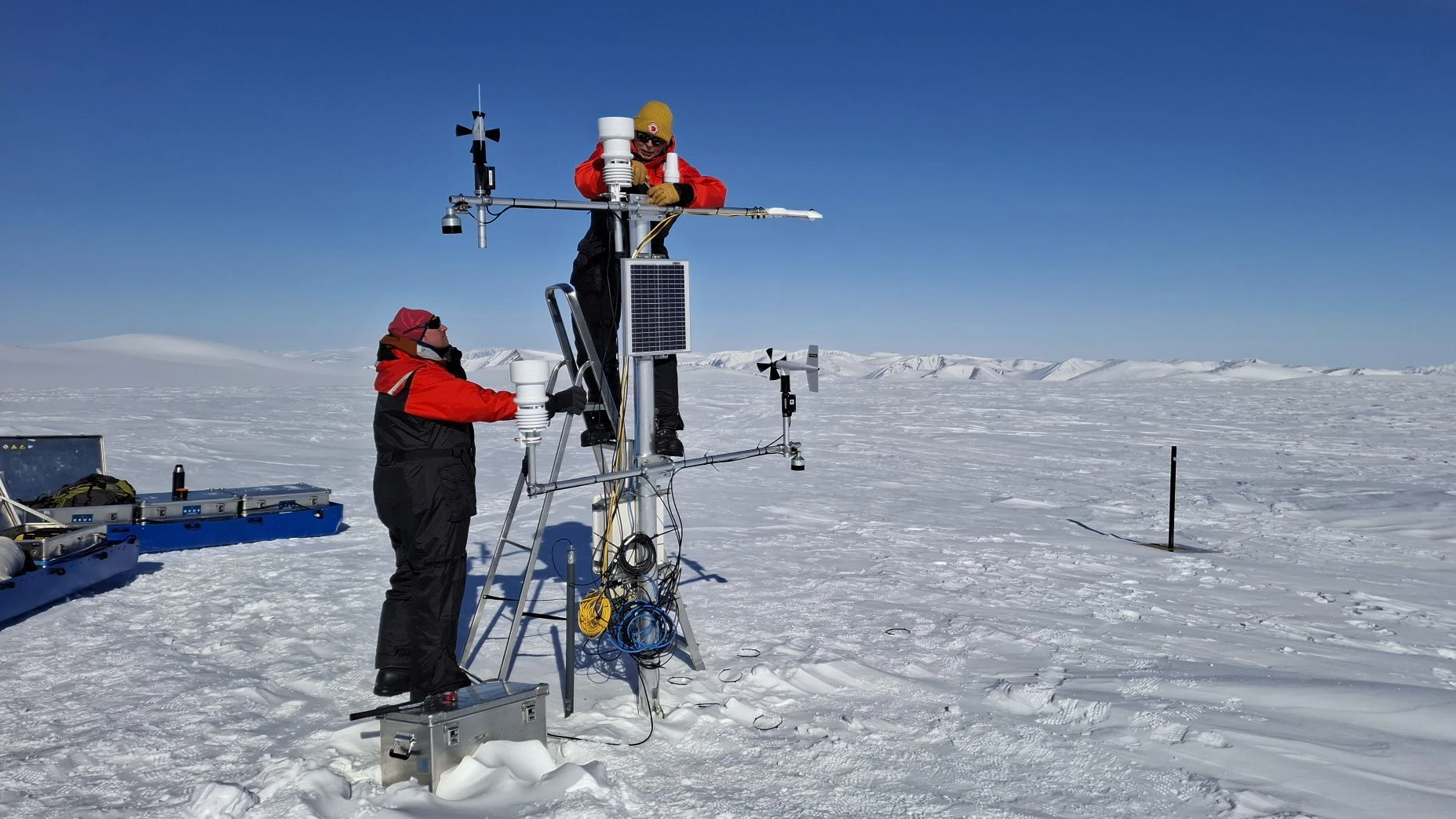 Arbeiten an einer automatischen Massenbilanz-Messstation auf einem Gletscher in Grönland.