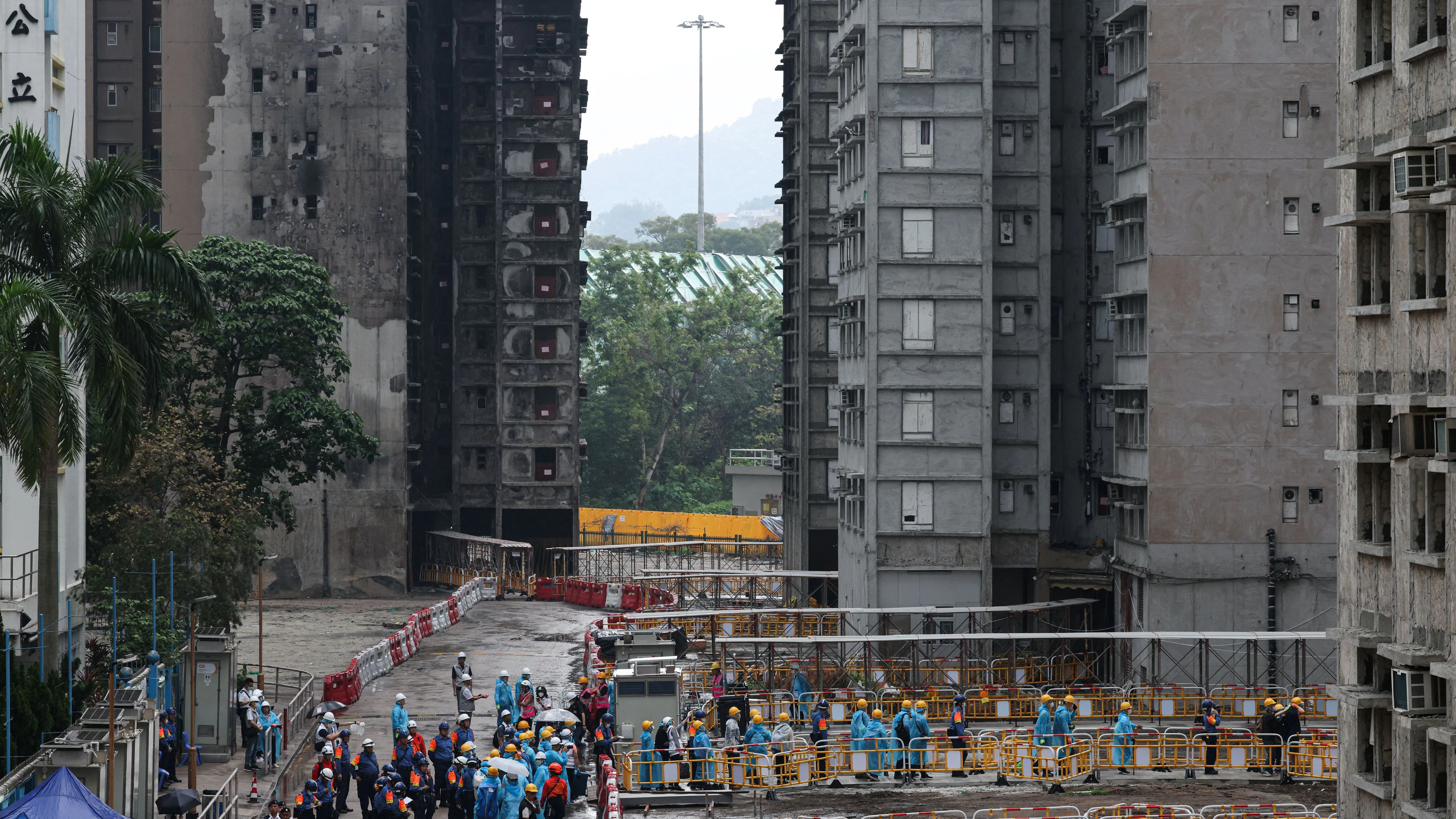 Residents walk towards a building at Wang Fuk Court to retrieve personal belongings on their first return visit after a deadly fire last year, in Hong Kong, China, April 20, 2026. REUTERS/Tyrone Siu