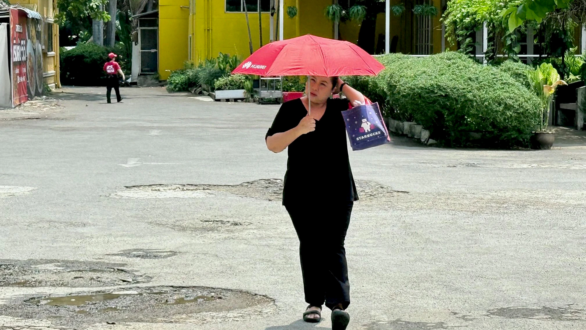 21 April 2026, Thailand, Bangkok: A woman protects herself from the heat with an umbrella. It has been unusually hot in Thailand for weeks. The authorities have now set up "cooling centers" where people can find relief. Photo: Carola Frentzen/dpa