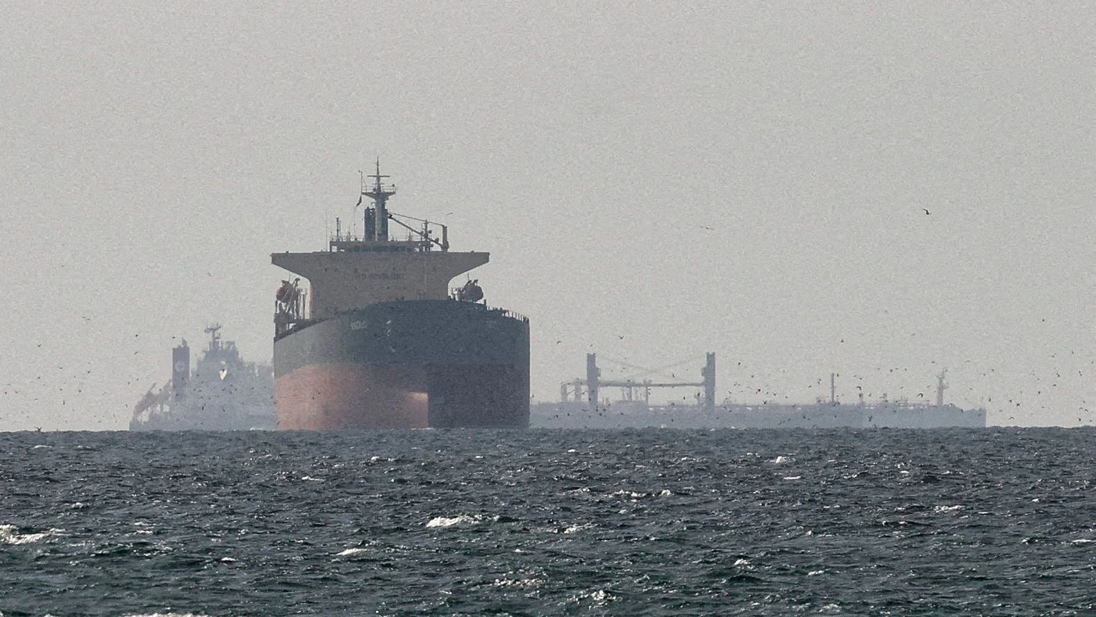 FILE PHOTO: Cargo ships in the Gulf, near the Strait of Hormuz, as seen from northern Ras al-Khaimah, near the border with Oman’s Musandam governance, amid the U.S.-Israeli conflict with Iran, in United Arab Emirates, March 11, 2026. REUTERS/Stringer/File Photo