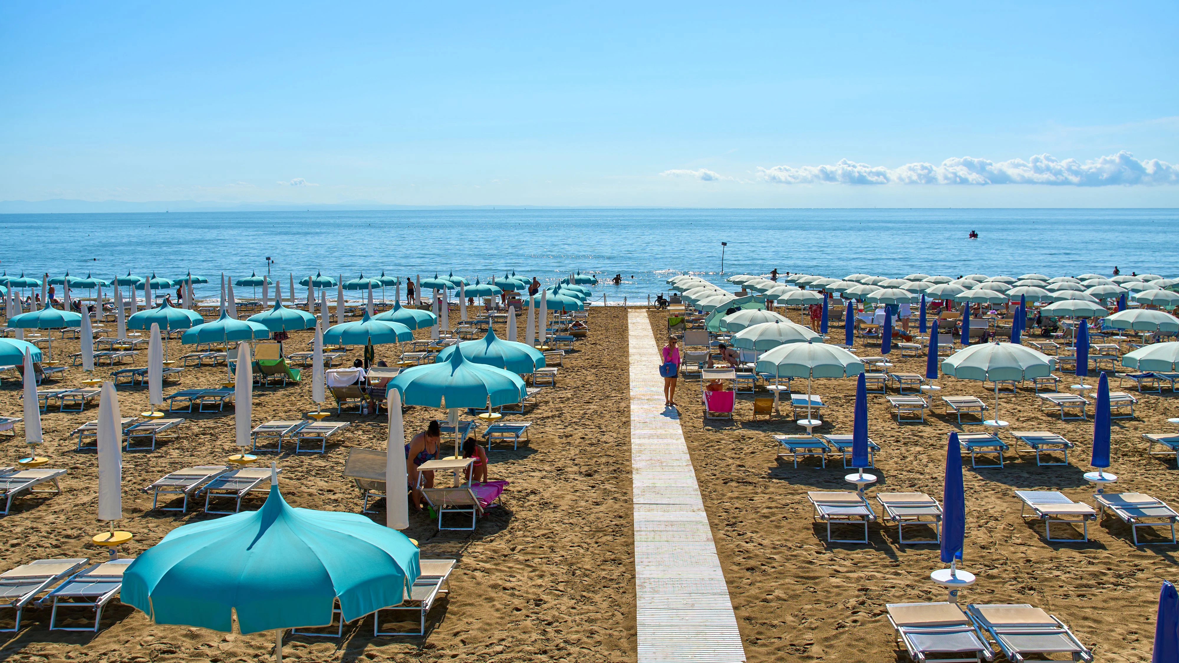 Strand von Lignano, Italien, im Sommer mit Sonnenschirmen und Liegestühlen