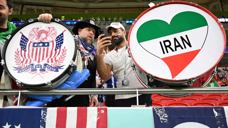 Am Persischen Golf sind sie erbitterte Feinde, bei der Fußball-WM spielen die USA und der Iran im selben Stadion. Aber während sich Amerika schwer damit tut, Fans zu mobilisieren, läuft der Verkauf für die Iran-Spiele super. Seltsam! Die Hintergründe.