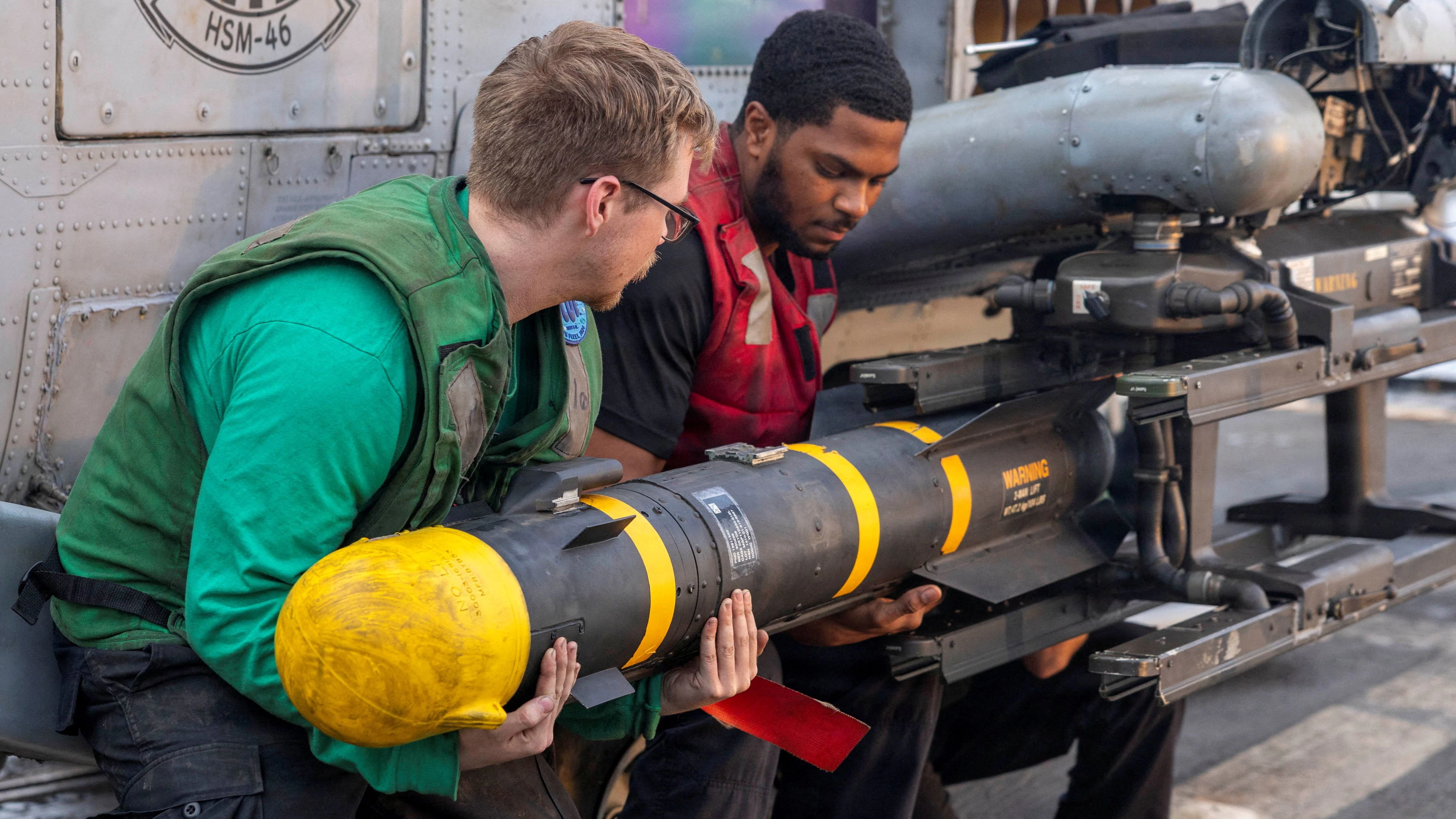 U.S. sailors, assigned to Helicopter Maritime Strike Squadron 46, unload an AGM-114 Hellfire missile from an MH-60R Sea Hawk helicopter on the flight deck of Arleigh Burke-class guided-missile destroyer USS Delbert D. Black supporting Operation Epic Fury during the Iran war at an undisclosed location, March 23, 2026. U.S. Navy/Handout via REUTERS ATTENTION EDITORS - THIS PICTURE WAS PROVIDED BY A THIRD PARTY     TPX IMAGES OF THE DAY     