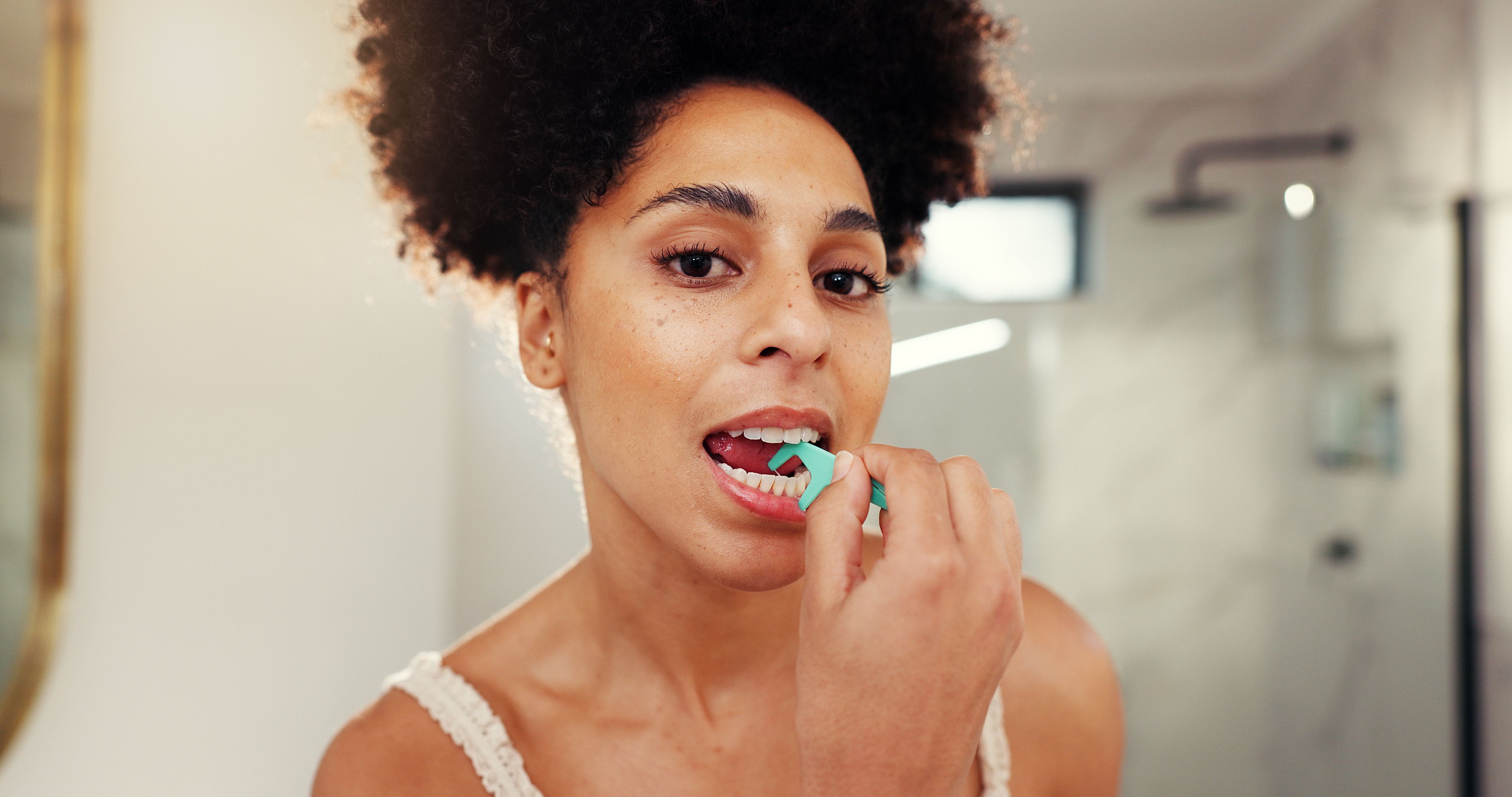 Frau benutzt Zahnseide...