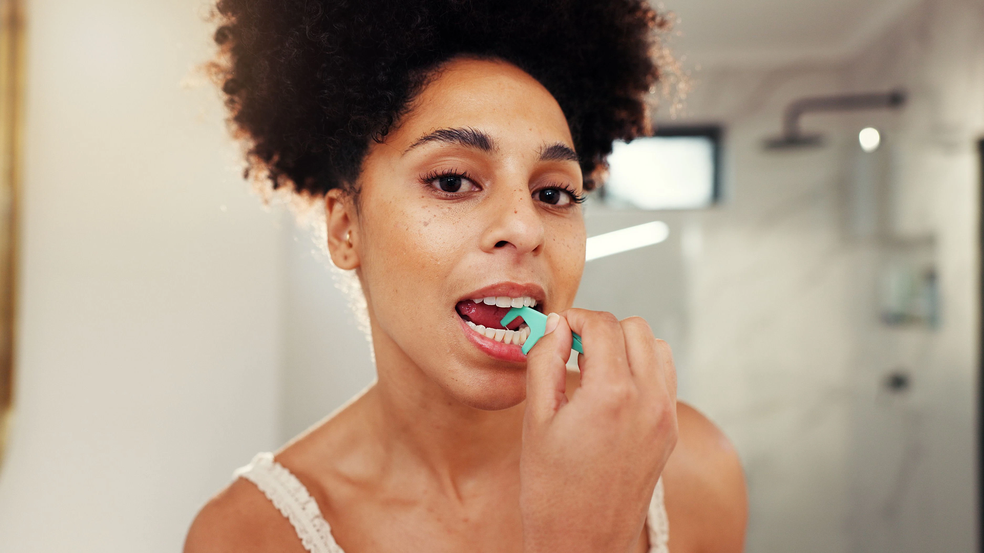 Frau benutzt Zahnseide...