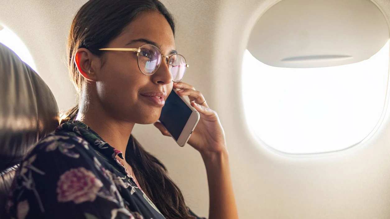 Beautiful woman talking on her phone in the plane