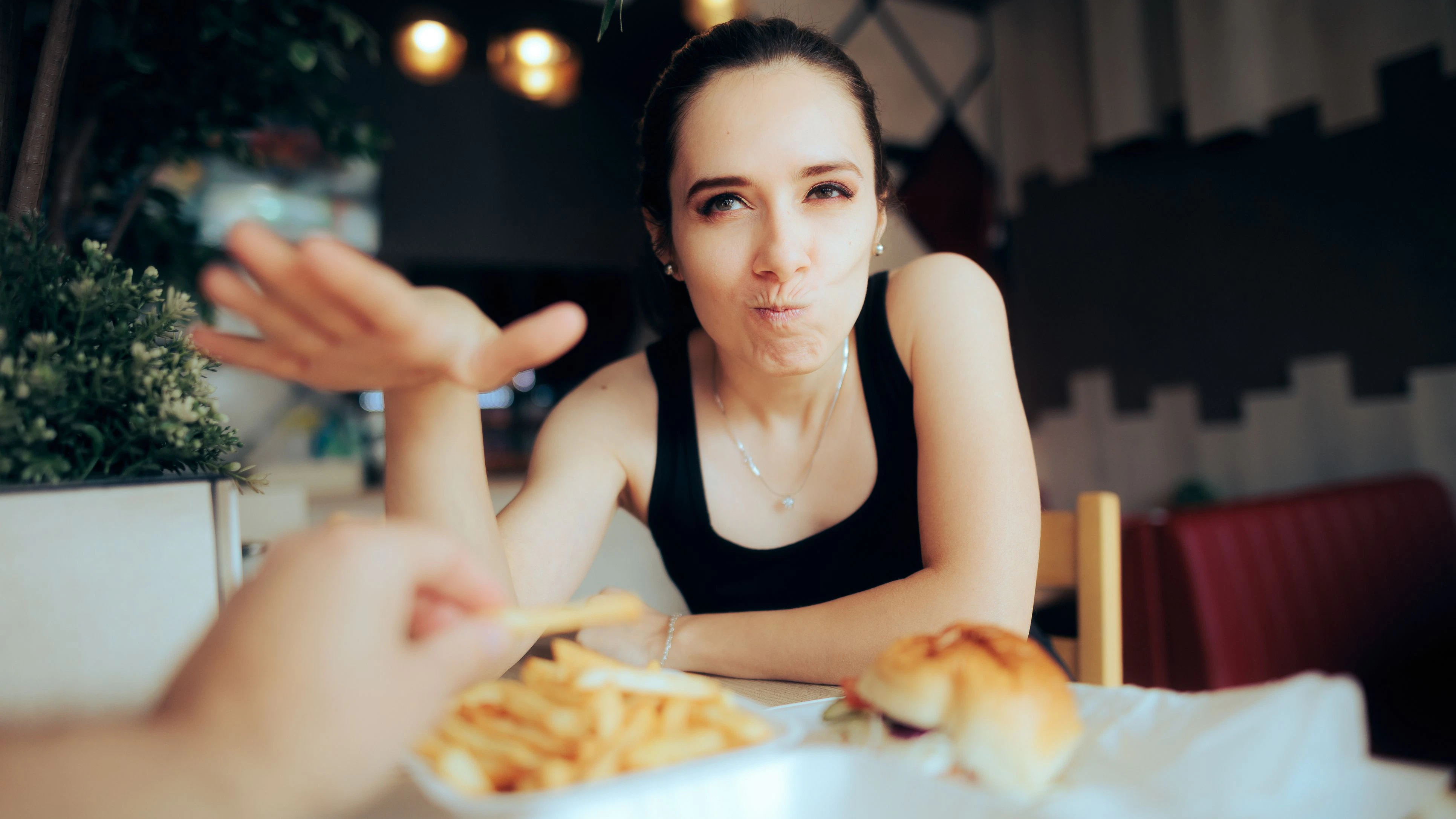 Unhappy woman not willing to share her meal with her date